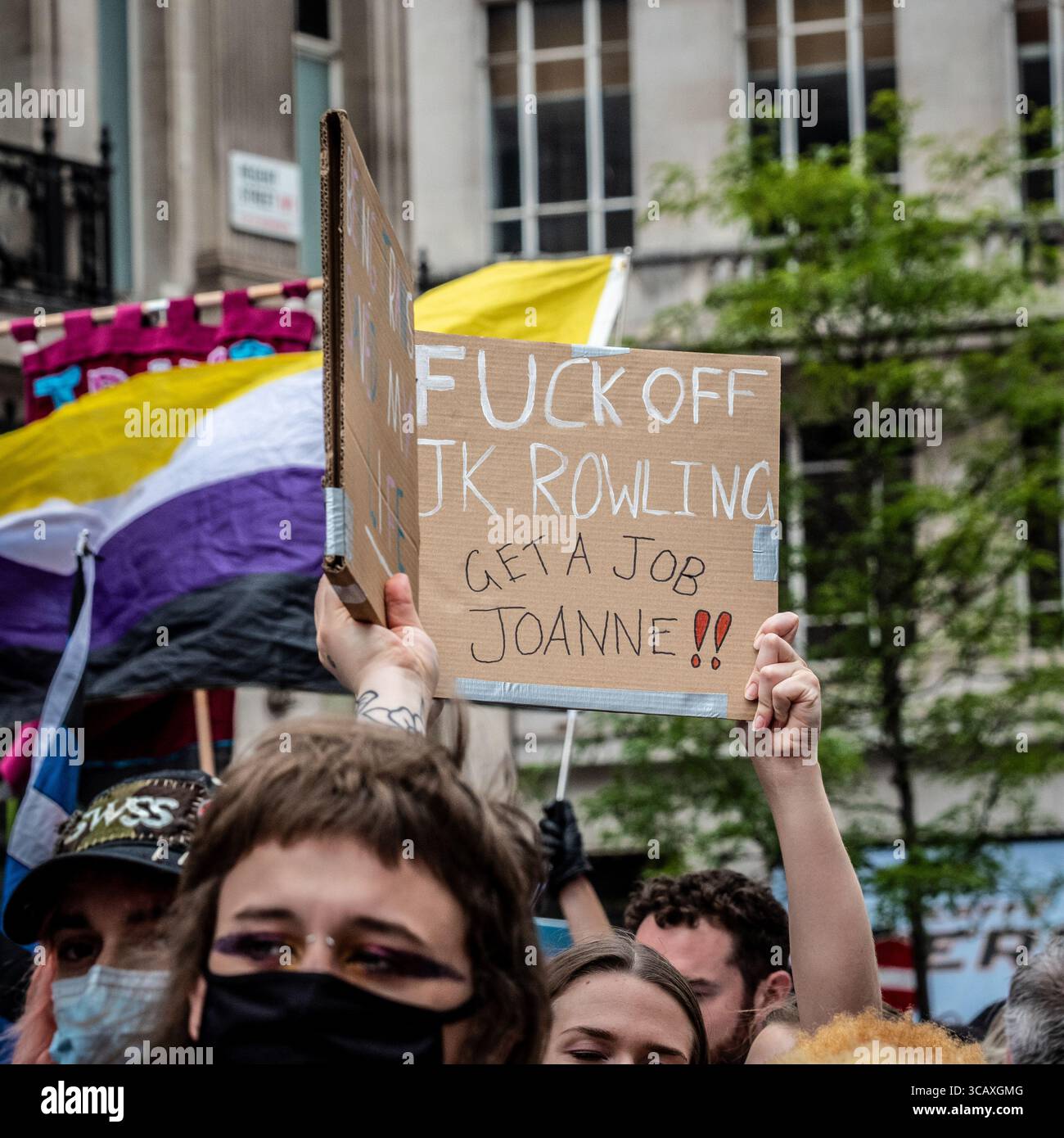 Ein Demonstrant hält ein Plakat, das den Autor JK Rowling während des jährlichen London Trans+ Pride march for Trans Rights in London kritisiert. Stockfoto