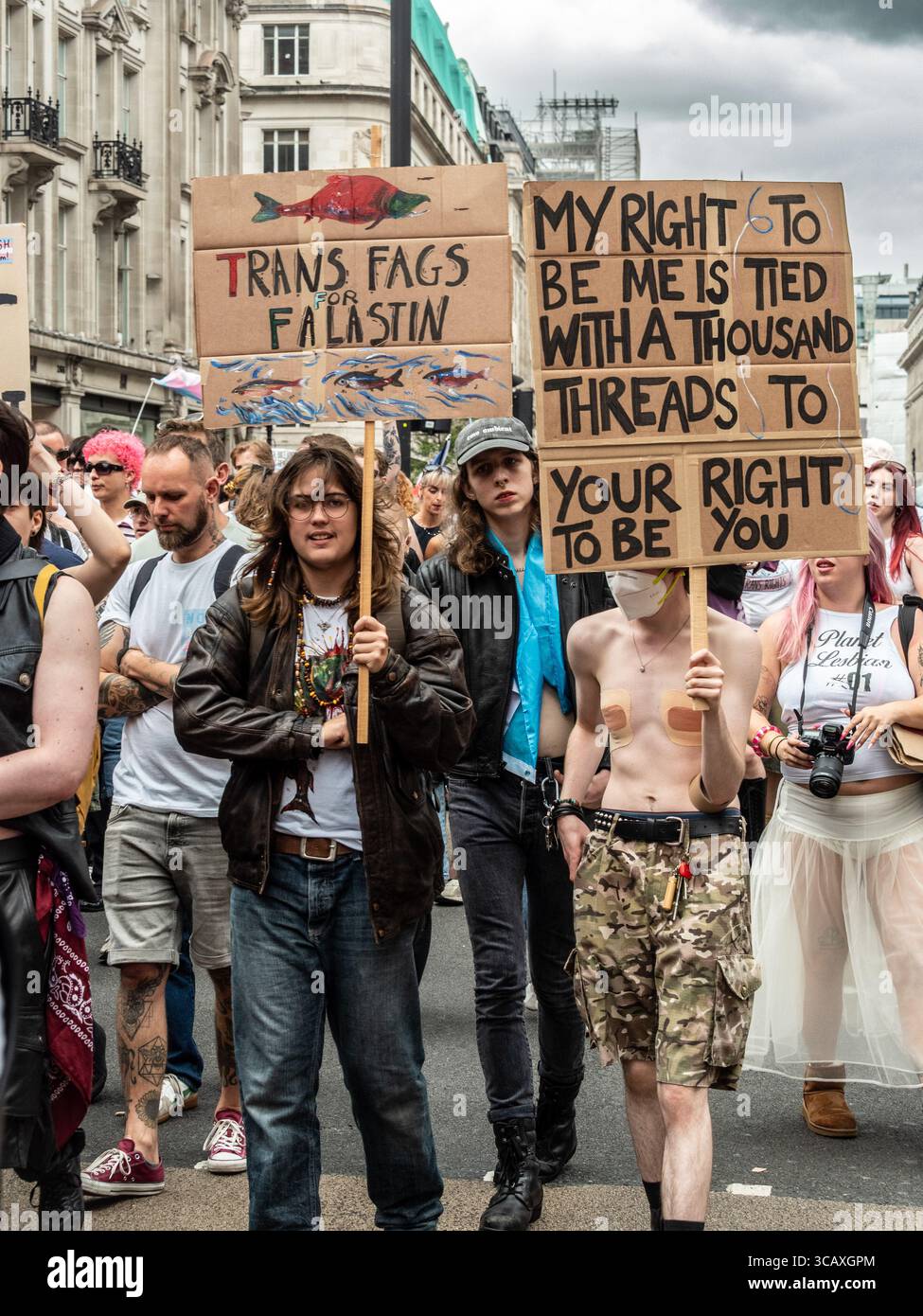 Demonstranten mit handgefertigten Schildern, die Solidarität und intersektionale Botschaften auf dem jährlichen London Trans+ Pride march in London zeigen. Stockfoto