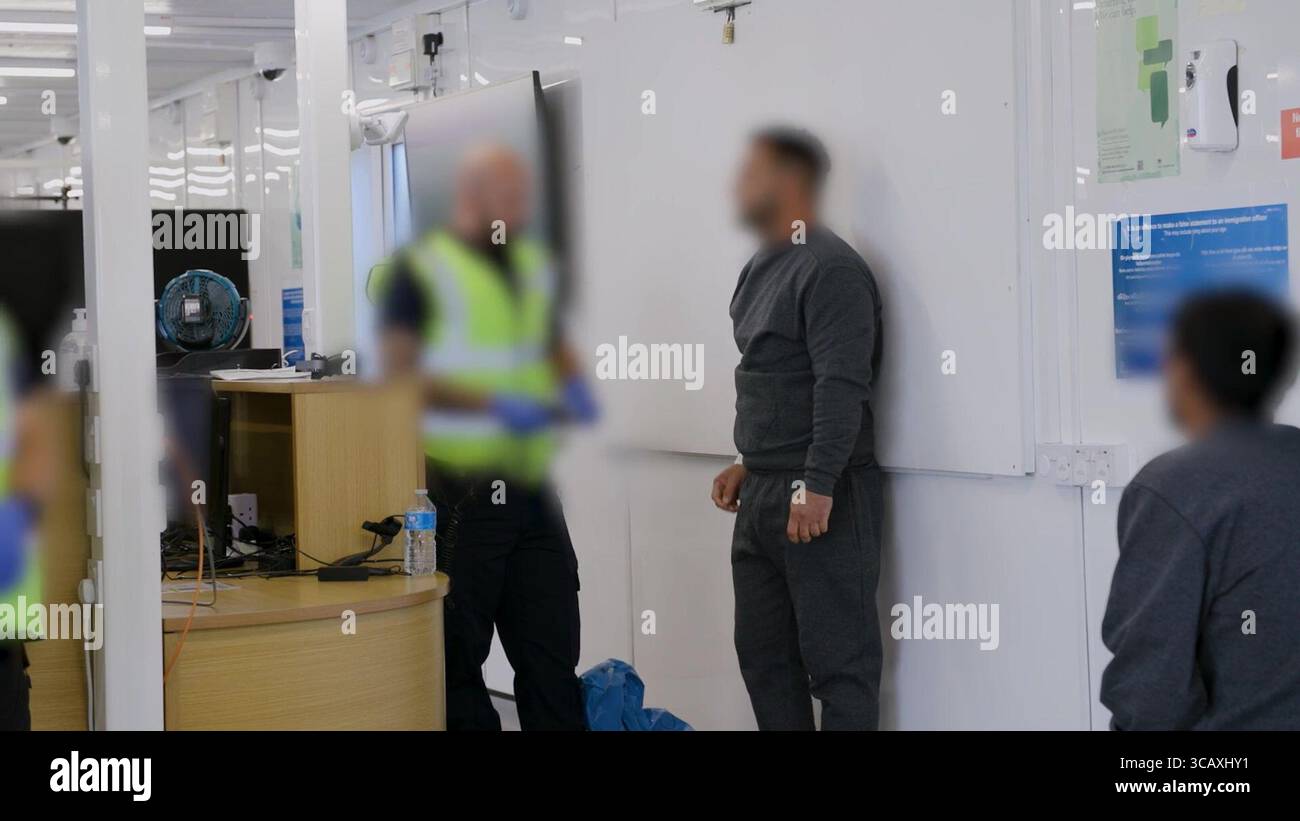 HINWEIS FÜR DIE REDAKTION: FILMMATERIAL IST AN DER QUELLE VERSCHWOMMEN. Screenshot aus dem Video des Innenministeriums der Grenzschutzbeamten, das die ersten kleinen Migranten verarbeitet, die im Rahmen des neuen britischen „One in, One Out“-Deals bei Western Jet Foil in Dover, Kent festgehalten wurden. Die Migranten, die am Tag der Inbetriebnahme des Pilotprogramms inhaftiert wurden, durchlaufen in den letzten 24 Stunden die ersten Phasen des Pilotprozesses für die Rückkehr zwischen Großbritannien und Frankreich, einschließlich der Erstbearbeitung, biometrischer und Sicherheitskontrollen sowie der Umsiedlung in das Abschiebungszentrum für Einwanderer, um auf ihre Rückkehr nach Frankreich zu warten. Bilddatum: Donnerstag, 7. August, Stockfoto