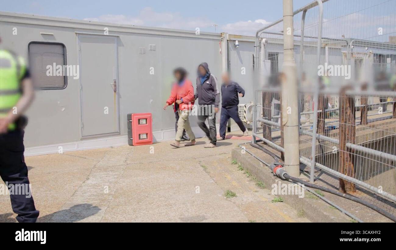 HINWEIS FÜR DIE REDAKTION: FILMMATERIAL IST AN DER QUELLE VERSCHWOMMEN. Screenshot aus dem Video des Innenministeriums der ersten Migranten mit kleinen Booten, die im Rahmen des neuen britischen „One in, One Out“-Deals bei Western Jet Foil in Dover, Kent festgehalten wurden. Die Migranten, die am Tag der Inbetriebnahme des Pilotprogramms inhaftiert wurden, durchlaufen in den letzten 24 Stunden die ersten Phasen des Pilotprozesses für die Rückkehr zwischen Großbritannien und Frankreich, einschließlich der Erstbearbeitung, biometrischer und Sicherheitskontrollen sowie der Umsiedlung in das Abschiebungszentrum für Einwanderer, um auf ihre Rückkehr nach Frankreich zu warten. Bilddatum: Donnerstag, 7. August 2025. Stockfoto