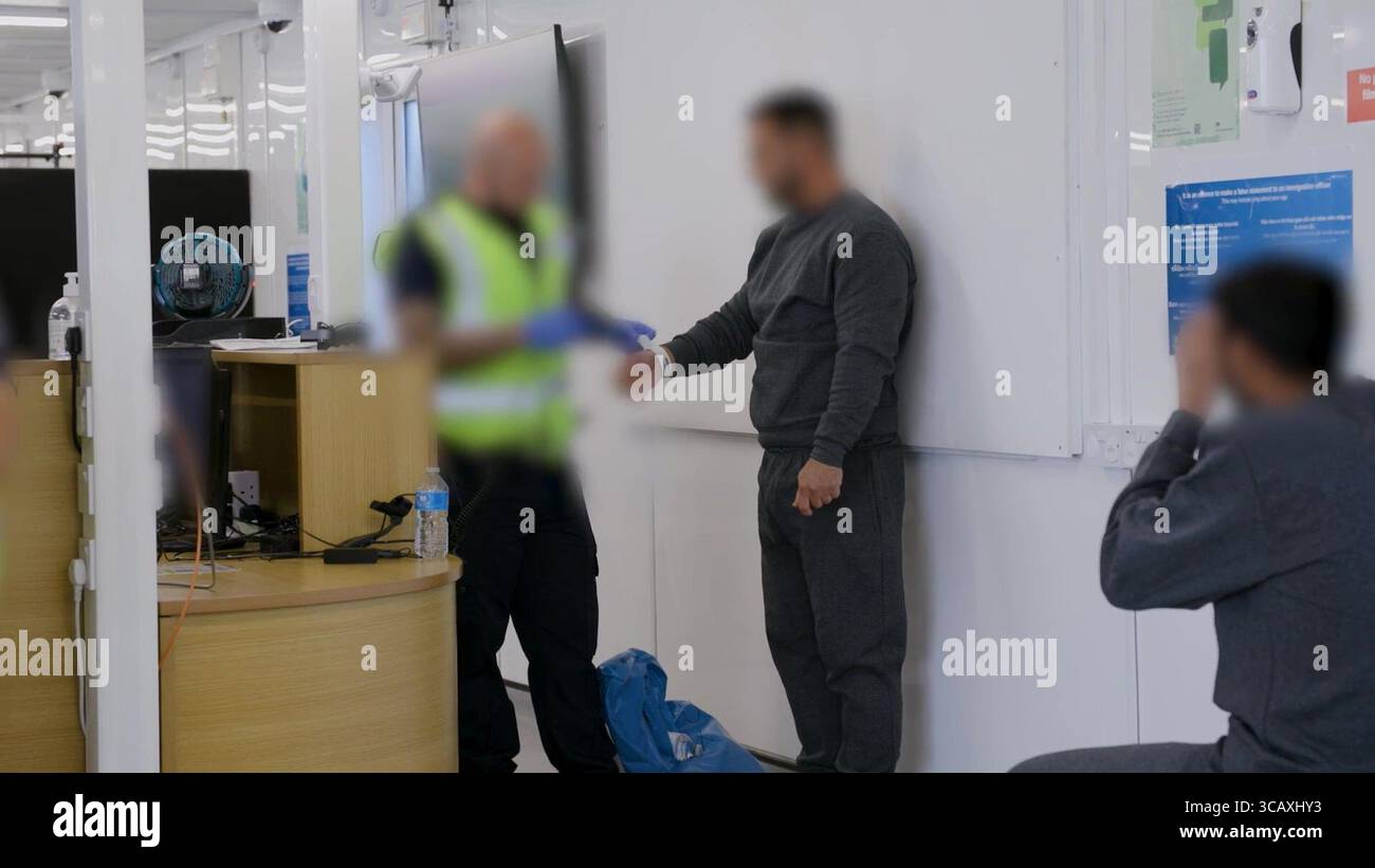 HINWEIS FÜR DIE REDAKTION: FILMMATERIAL IST AN DER QUELLE VERSCHWOMMEN. Screenshot aus dem Video des Innenministeriums der Grenzschutzbeamten, das die ersten kleinen Migranten verarbeitet, die im Rahmen des neuen britischen „One in, One Out“-Deals bei Western Jet Foil in Dover, Kent festgehalten wurden. Die Migranten, die am Tag der Inbetriebnahme des Pilotprogramms inhaftiert wurden, durchlaufen in den letzten 24 Stunden die ersten Phasen des Pilotprozesses für die Rückkehr zwischen Großbritannien und Frankreich, einschließlich der Erstbearbeitung, biometrischer und Sicherheitskontrollen sowie der Umsiedlung in das Abschiebungszentrum für Einwanderer, um auf ihre Rückkehr nach Frankreich zu warten. Bilddatum: Donnerstag, 7. August, Stockfoto