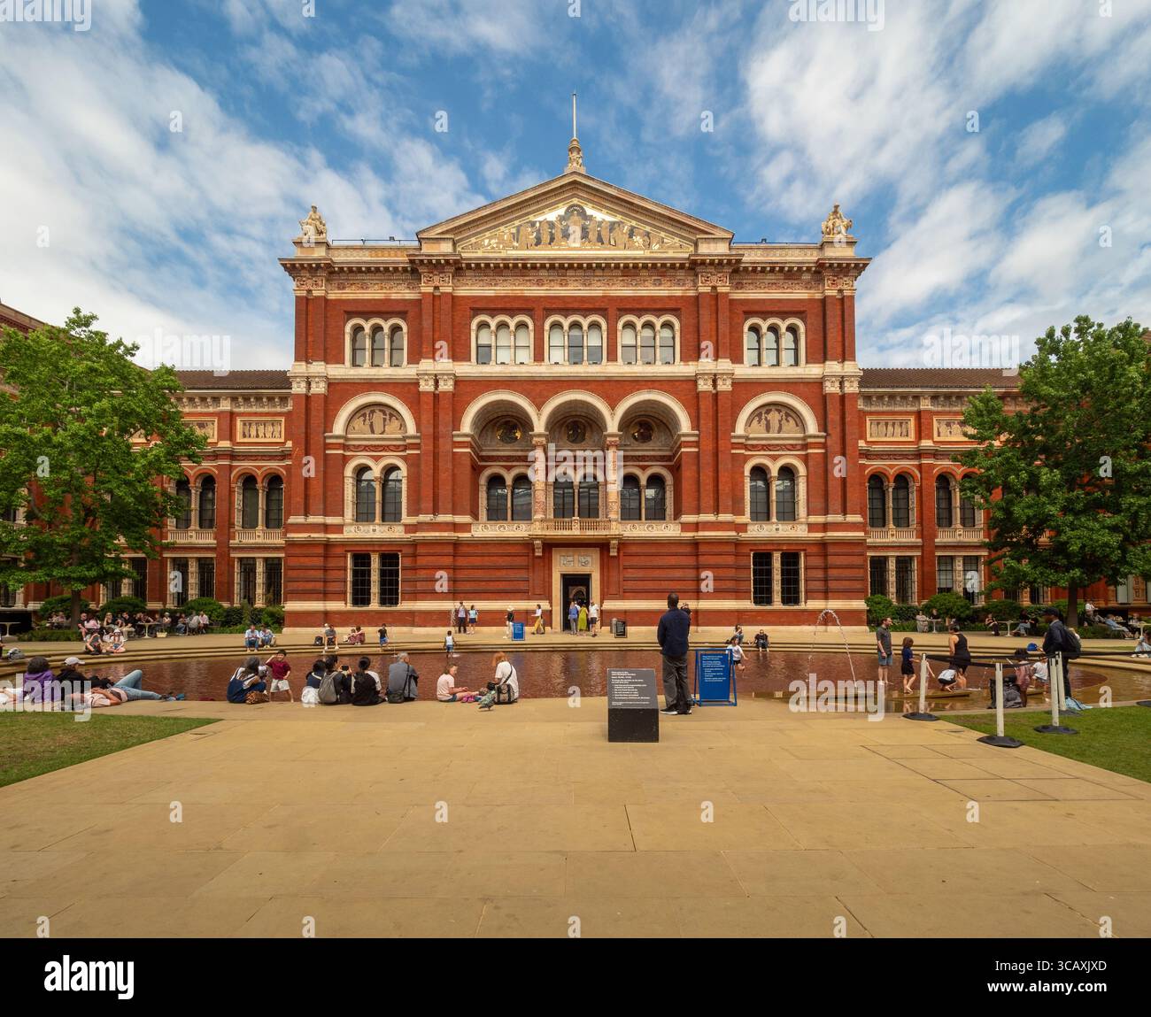 Menschen, die sich an einem Sommertag in London, Großbritannien, im John Madejski Garden, dem zentralen Innenhof des Victoria and Albert Museum (V&A), entspannen. Stockfoto
