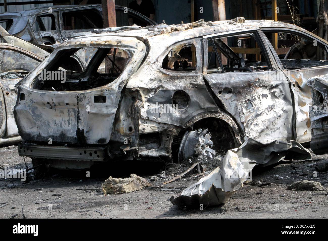 Nicht exklusiv: Ein kalziniertes Auto, das infolge eines russischen Drohnenangriffs in Brand geriet, befindet sich am 7. August 2025 auf der Straße in Dnipro, Ukraine. Vier pe Stockfoto