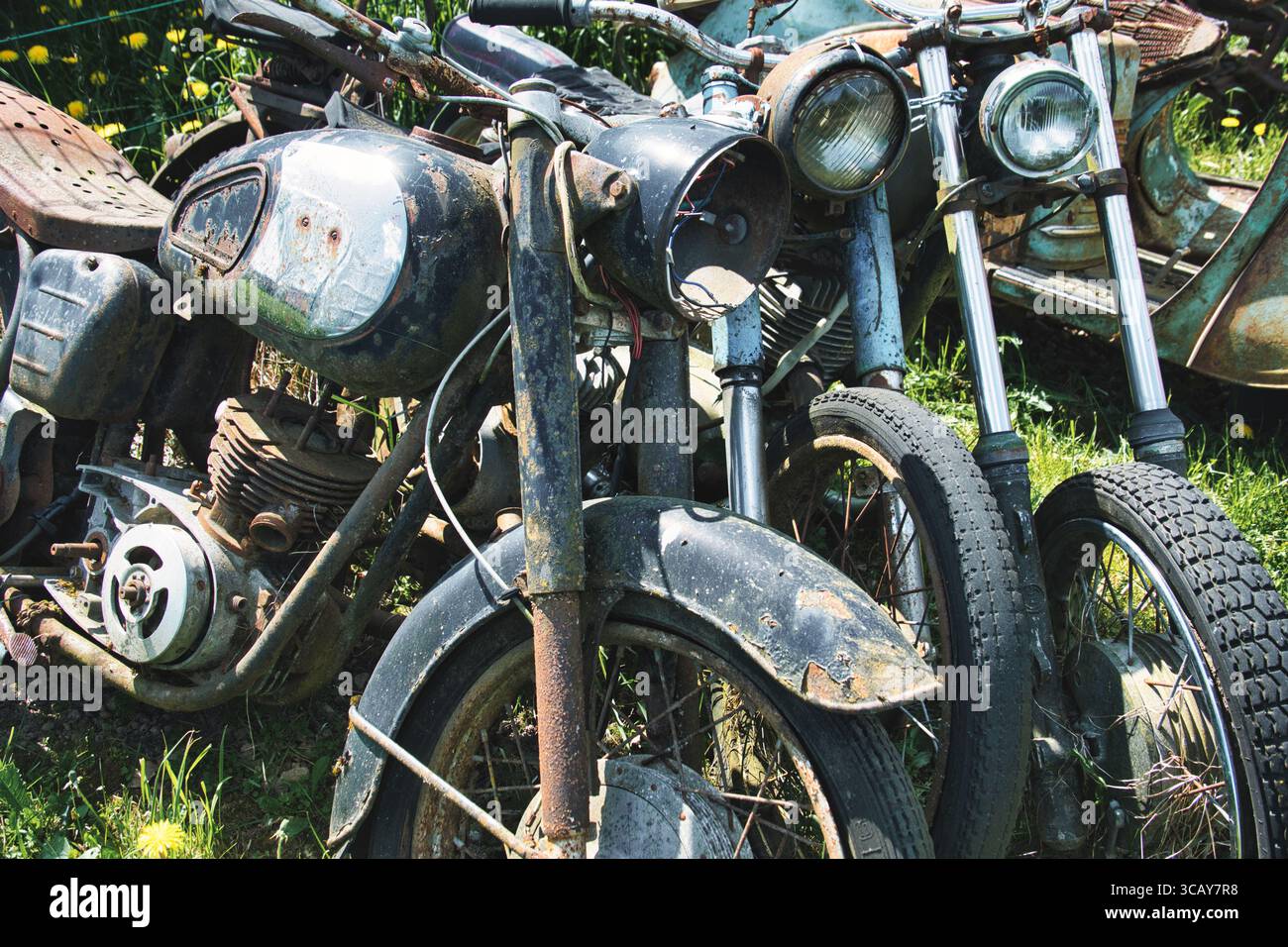 Rostige Vintage-Motorräder, die in Grass aufgegeben wurden – sowjetische Klassiker Stockfoto