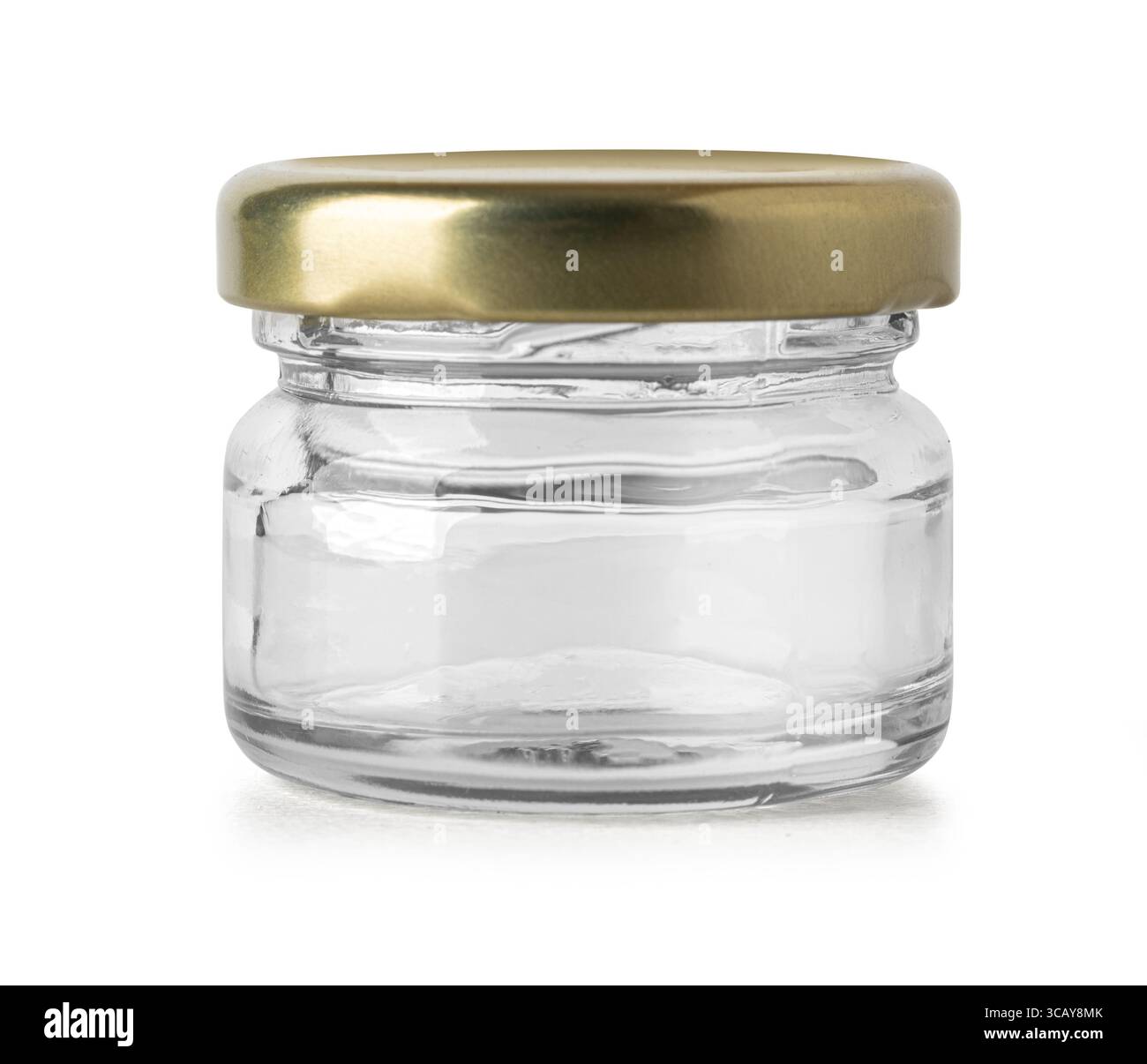 Studio-Aufnahme eines kleinen, leeren Glasbehälters mit goldenem Deckel, perfekt zum Aufbewahren von Gewürzen, Marmeladen oder anderen kleinen Gegenständen Stockfoto