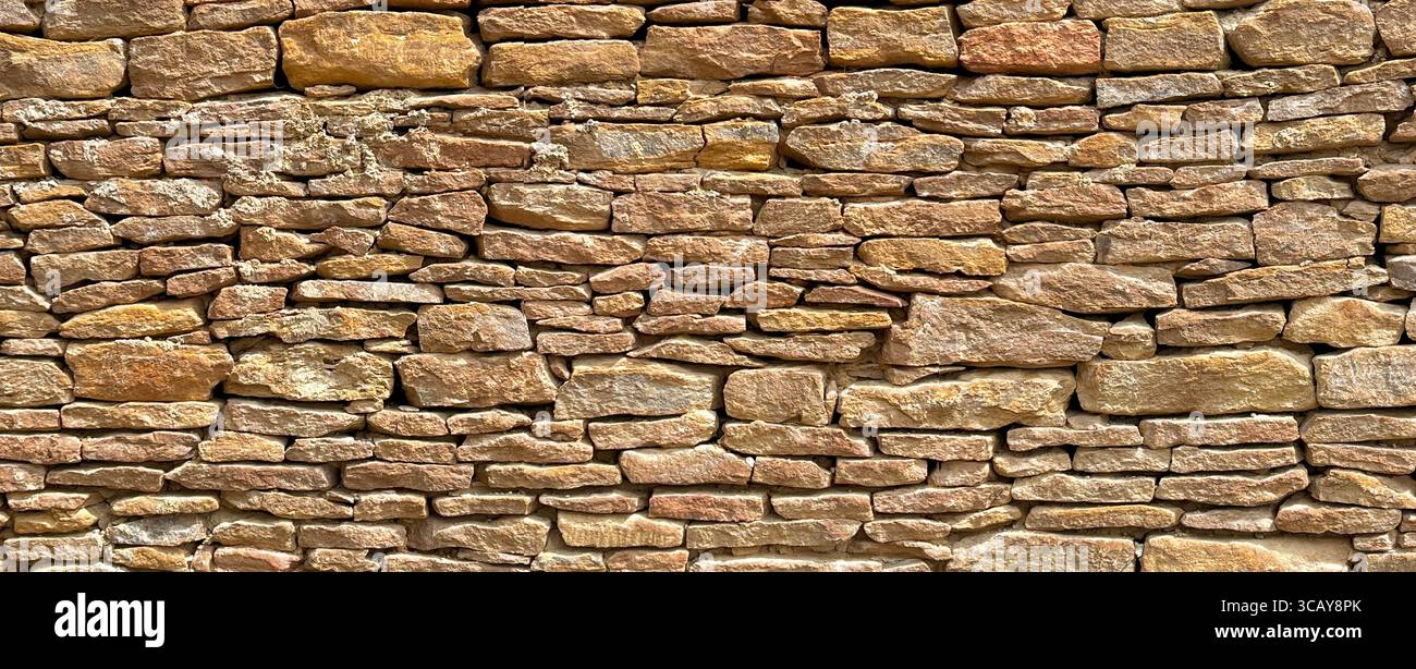 Nahaufnahme einer alten Steinmauer, die das strukturierte Mauerwerk hervorhebt und eine rustikale, zeitlose Kulisse schafft Stockfoto