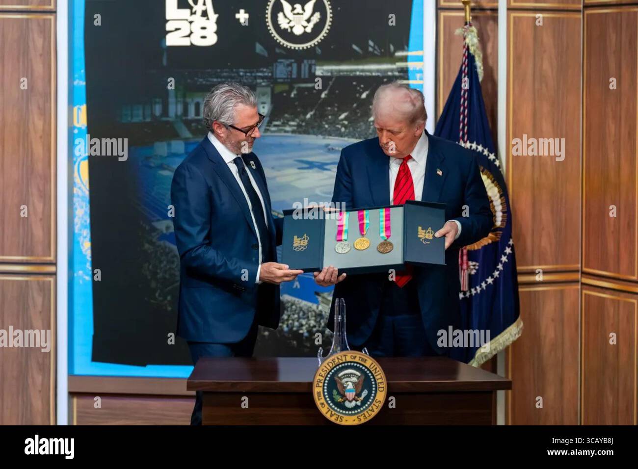 Präsident Donald J. Trump hält eine Gedenkbox mit den Gold-, Silber- und Bronzemedaillen für die Olympischen und Paralympischen Spiele 2028 in Los Angeles während einer Zeremonie im Andrew W. Mellon Auditorium in Washington, D.C. am 5. August 2025. Trump erhielt die Medaillen im Rahmen des Starts der Task Force des Weißen Hauses für die LA28. Bild mit freundlicher Genehmigung des Weißen Hauses. Stockfoto