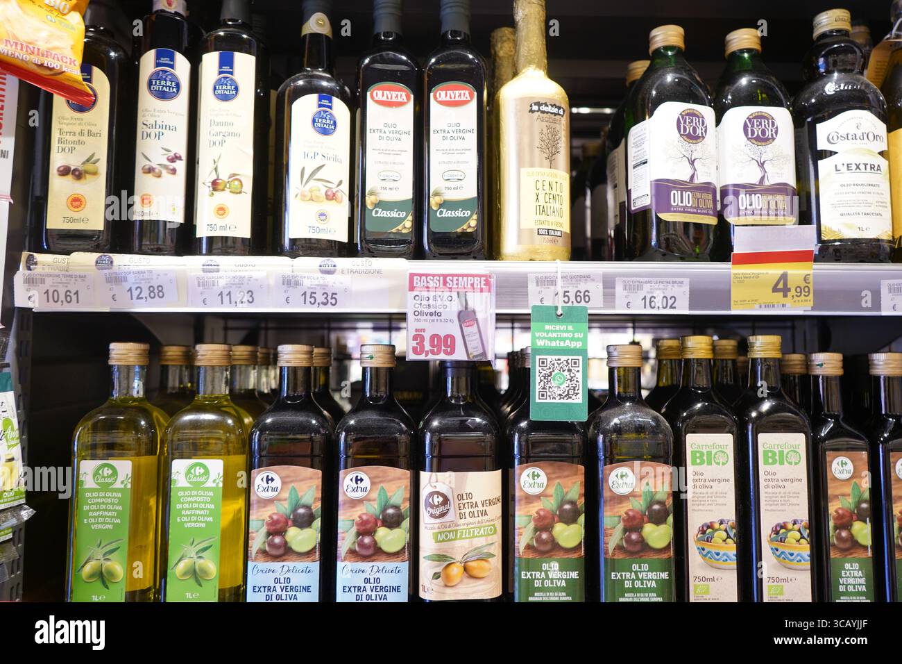 In den Regalen von Carrefour finden Sie eine große Auswahl an nativen italienischen Olivenölen extra, die regionale Etiketten, Branding und verschiedene Preisoptionen präsentieren. Stockfoto