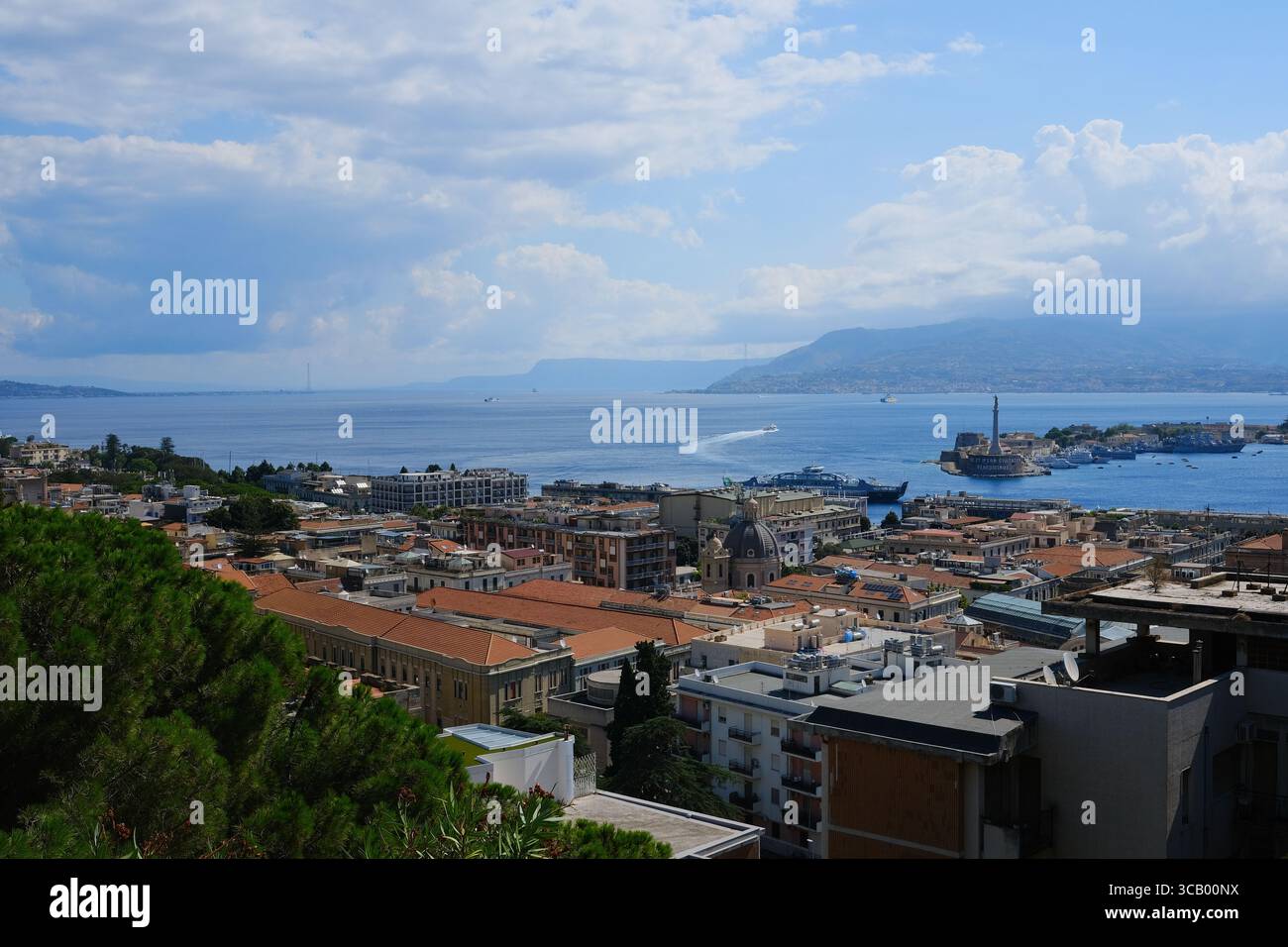 Weite Luftaufnahme der Meerenge von Messina, Süditalien, mit Fährschiffen, die das Meer in Richtung Hafen überqueren. Der natürliche Wasserweg, der Sizilien trennt Stockfoto