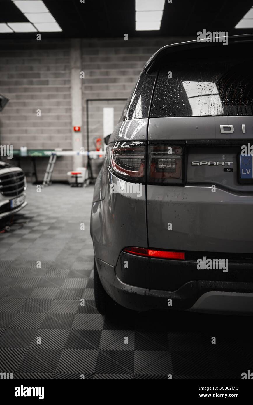 Rückansicht des Silver Range Rover Discovery Sport in der modernen Garage Stockfoto