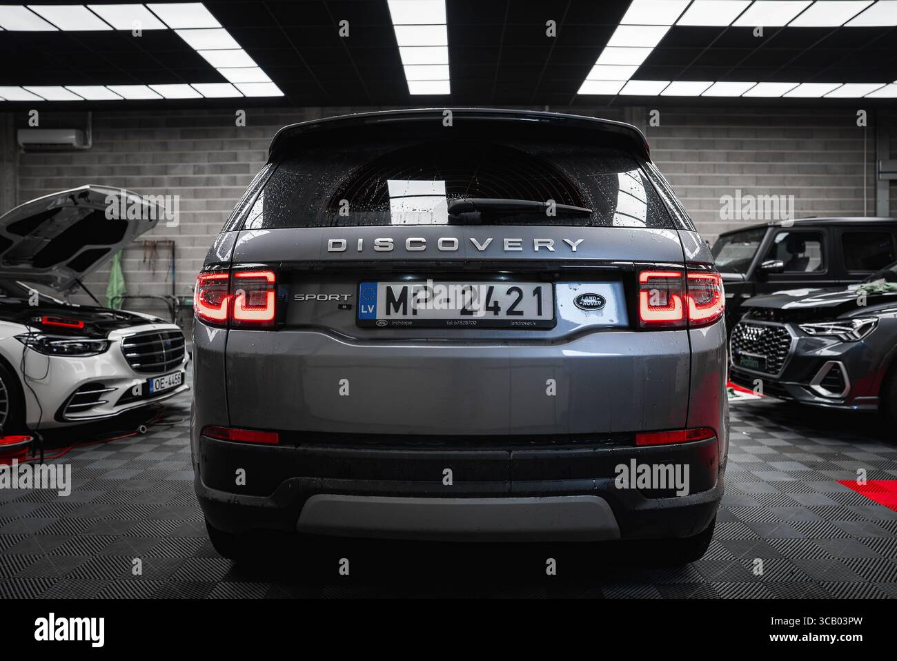 Rückansicht des Silver Range Rover Discovery Sport in der Werkstatt Stockfoto