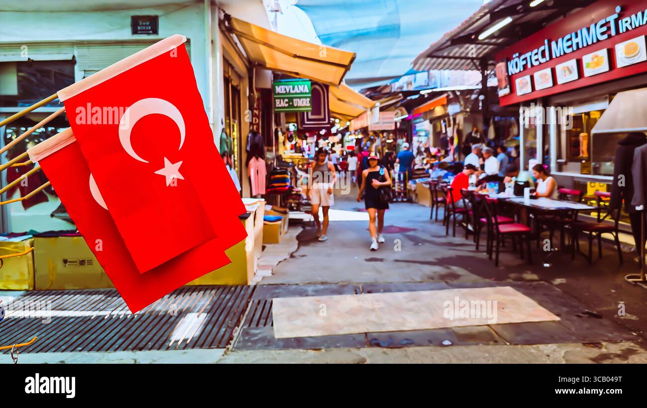 Izmir, Türkei. August 2025. Tägliches Leben auf einem traditionellen türkischen Basar im Sommer sind türkische Flaggen sichtbar, und die Atmosphäre ist lebhaft mit lokalen Geschäften, Straßenrestaurants und Touristen, die den Markt in Izmir, Türkei, erkunden. Fängt das Wesen der türkischen Kultur, Gastfreundschaft und des Gemeindelebens ein. Quelle: İdil Toffolo/Alamy Live News Stockfoto