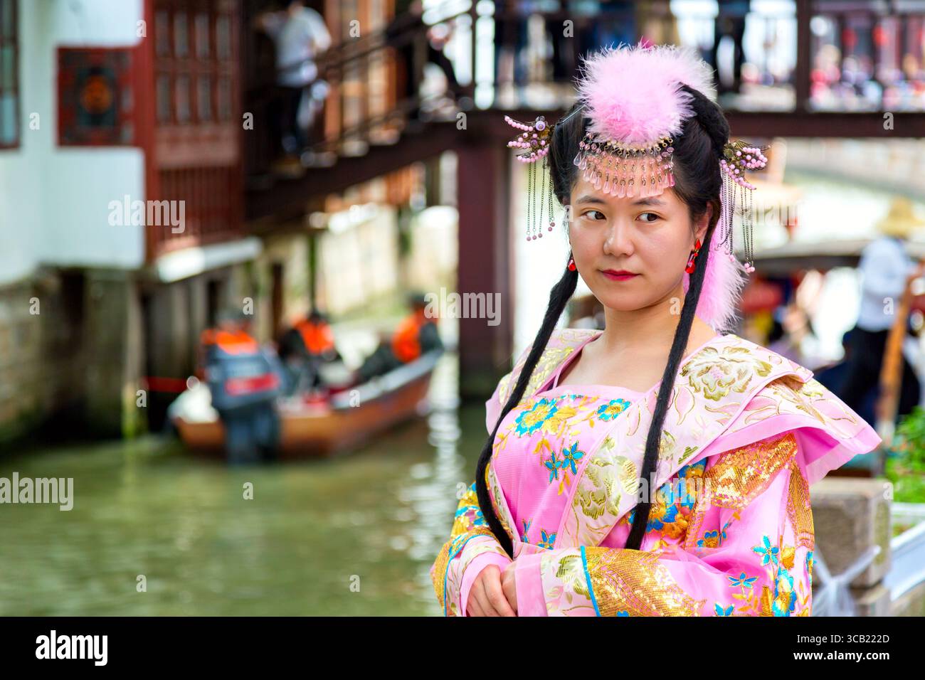 Shanghai, China - Mai 2019: Chinesisch schöne asiatische Frau in Nationalkleidung gegen die antike Stadt Shanghai Zhujiajiao in Shanghai, China. Chinesisches Veni Stockfoto