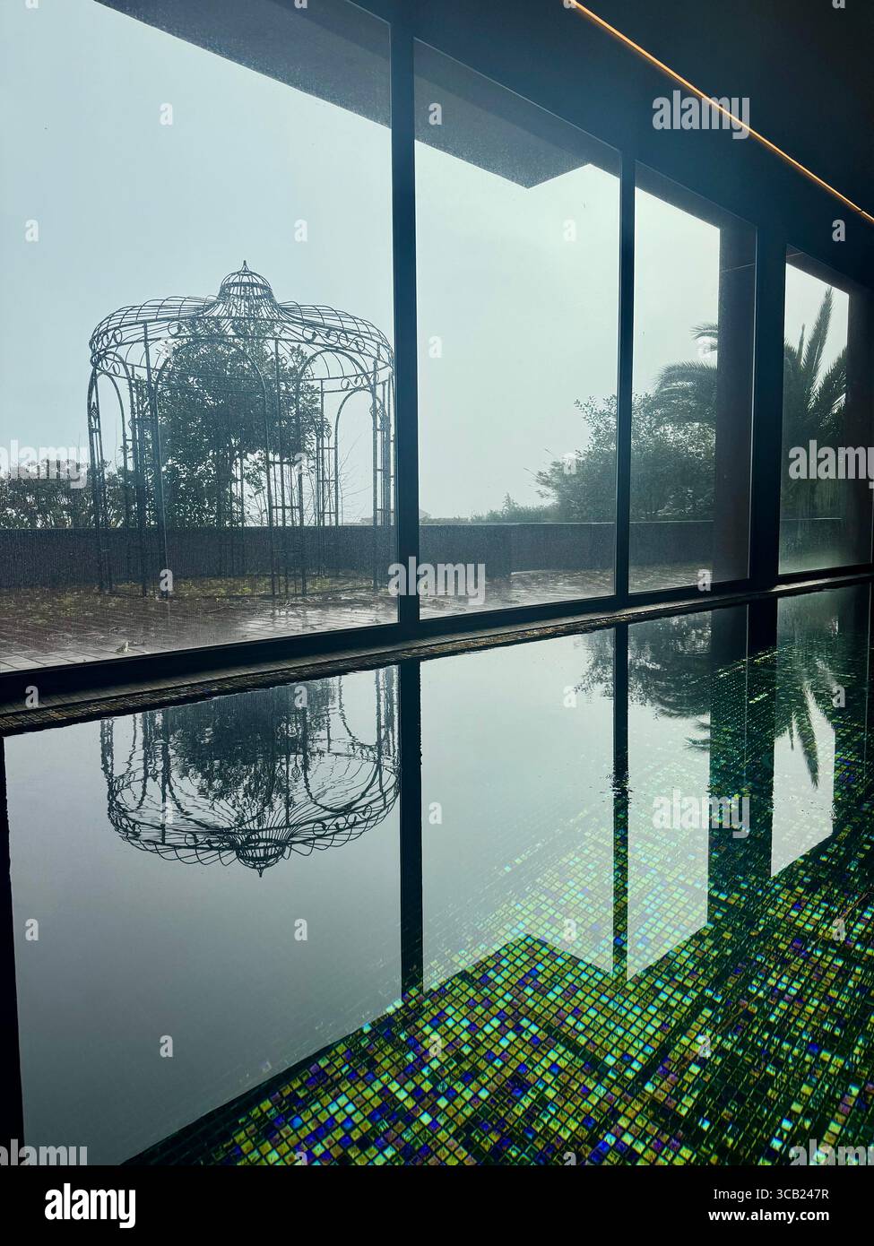 Reflektierender Innenpool mit Mosaikfliesen und dekorativen Außenskulpturen im Lince Nordeste Country Hotel für eine ruhige Atmosphäre. - Smartphone-aufgenommenes Stockfoto