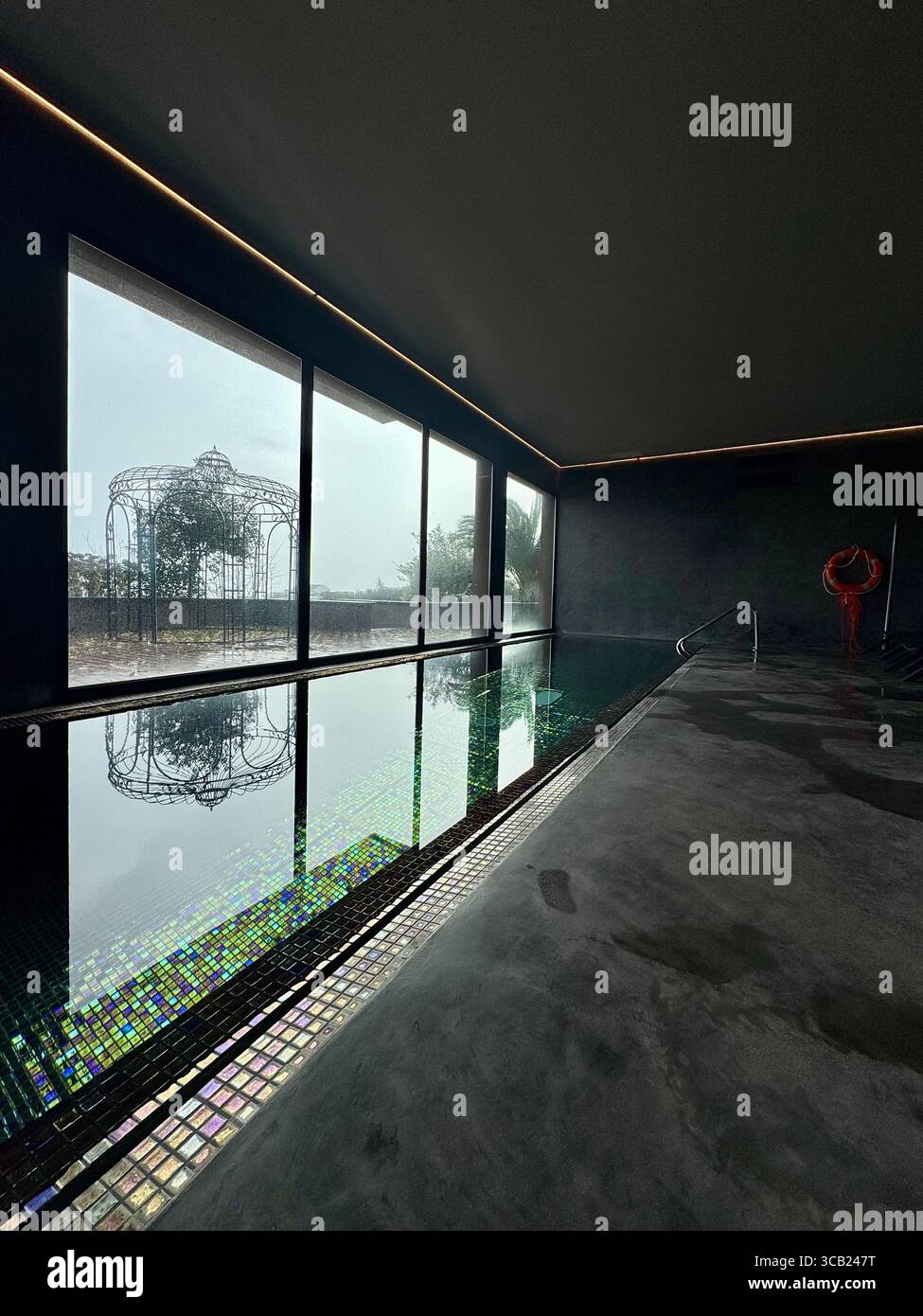 Reflektierender Innenpool mit Mosaikfliesen und dekorativen Außenskulpturen im Lince Nordeste Country Hotel für eine ruhige Atmosphäre. - Smartphone-aufgenommenes Stockfoto