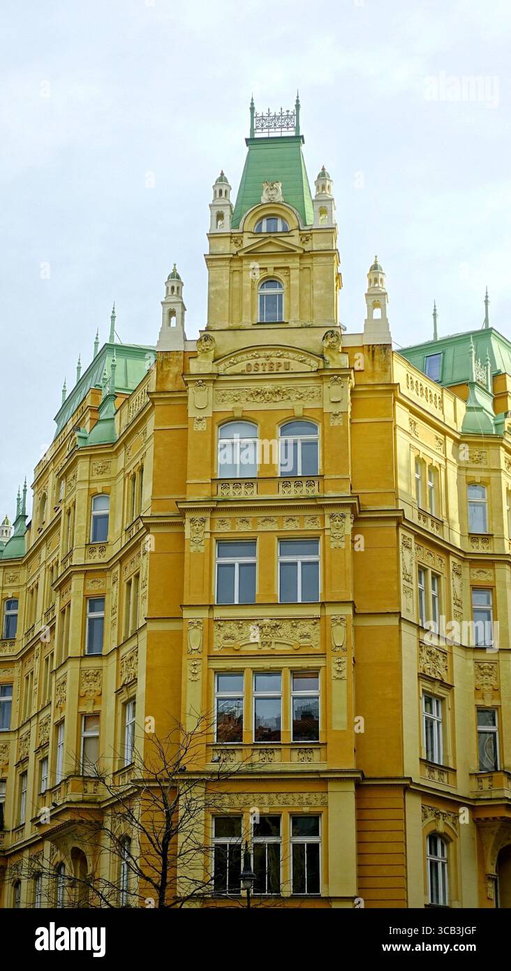 Wunderschönes, symmetrisches, gelbes Eckgebäude mit grünen Türmchen im jüdischen Viertel Josefov in Prag, Tschechien Stockfoto