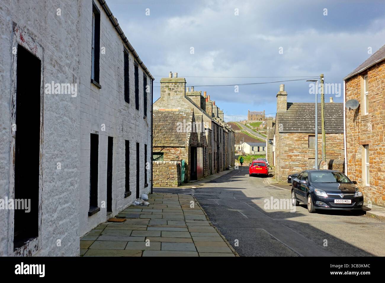 Eine typische Straße mit alten Steinhäusern im kleinen malerischen Fischerdorf St. Margaret's Hope auf der Insel South Ronaldsay in Orkney, Schottland Stockfoto