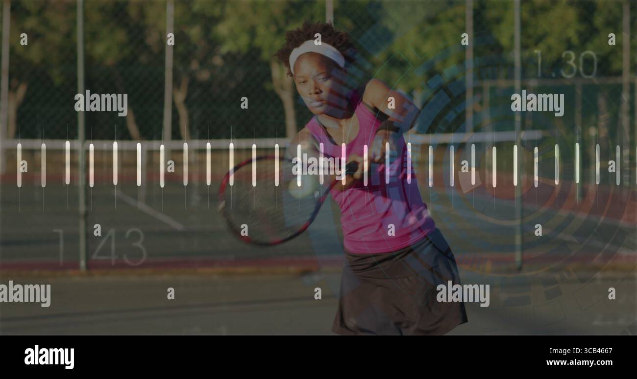 Schwungvolle Sportfrau in Sportbekleidung auf dem Tennisplatz, mit Schläger, Ball, Kettenzaun Stockfoto