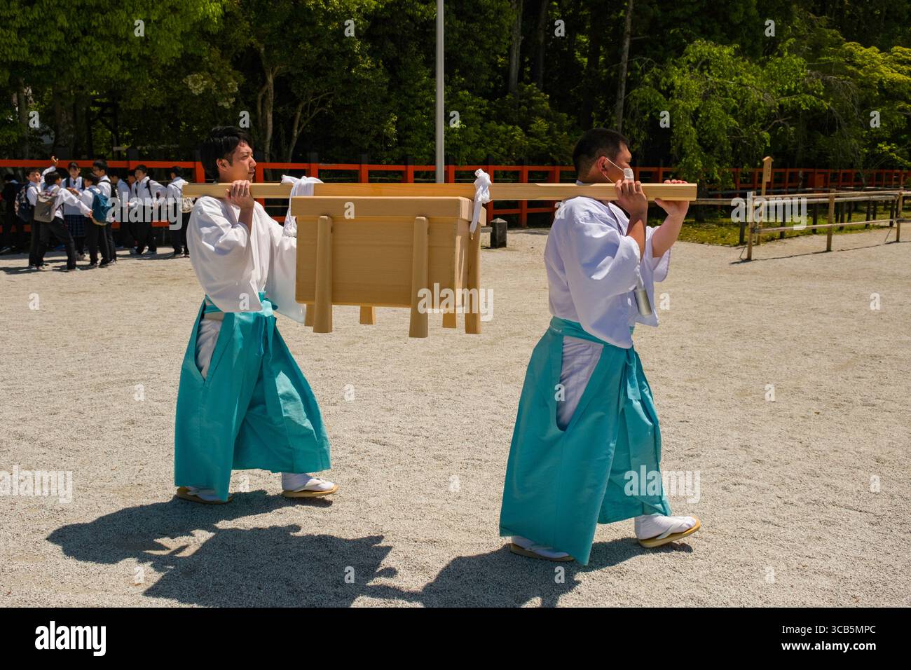 Shinto-Prozession am Kamigamo-Schrein mit Personen in traditioneller Kleidung tragen während einer kulturellen Zeremonie in Kyoto, Japan, eine Holzstruktur im Freien Stockfoto