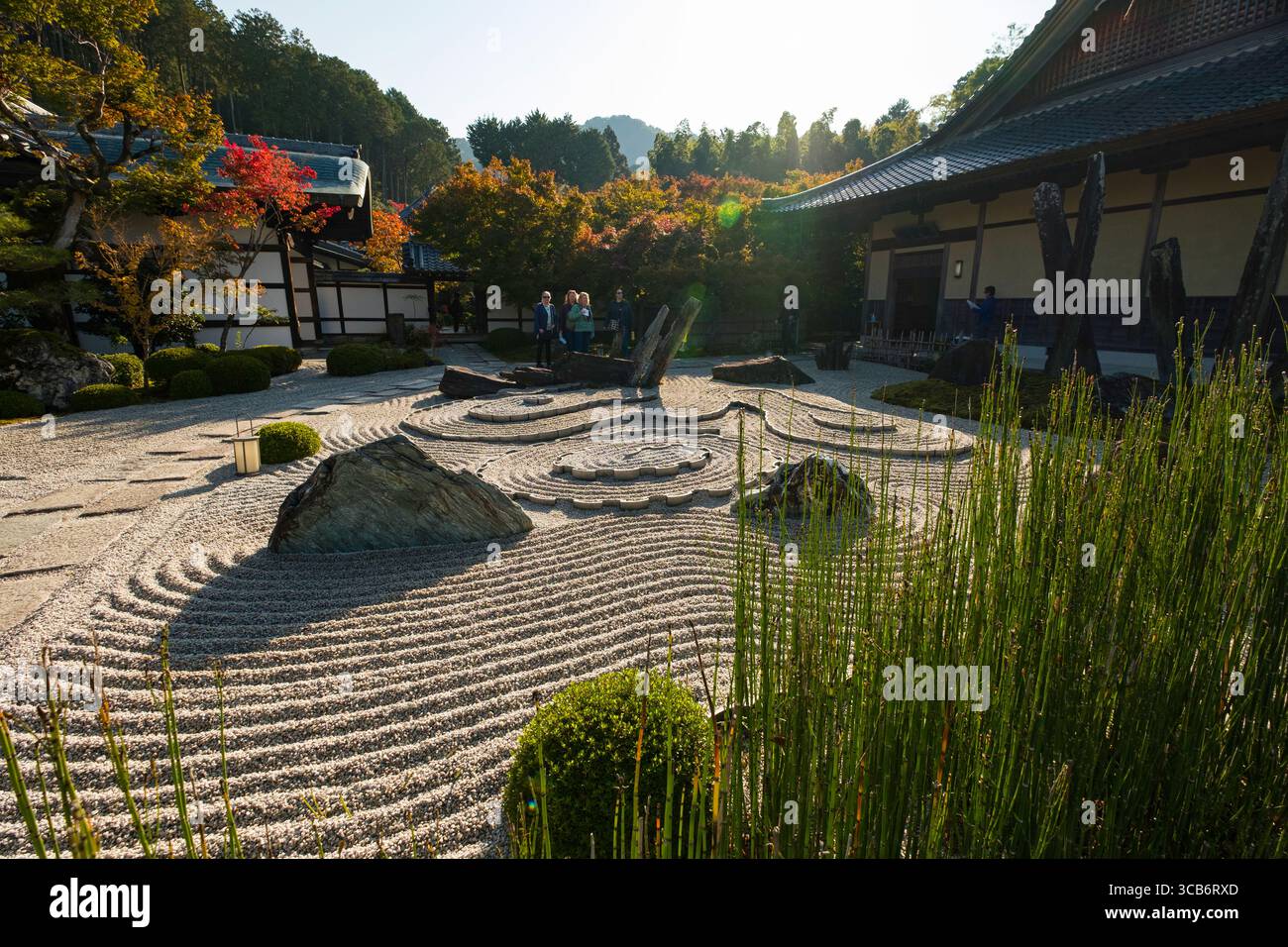 Die Ruhe ist umgeben von einem sorgfältig strukturierten japanischen Zen-Garten mit harmonischen Steinanordnungen, geharkten Kiesmustern und traditionellem W Stockfoto