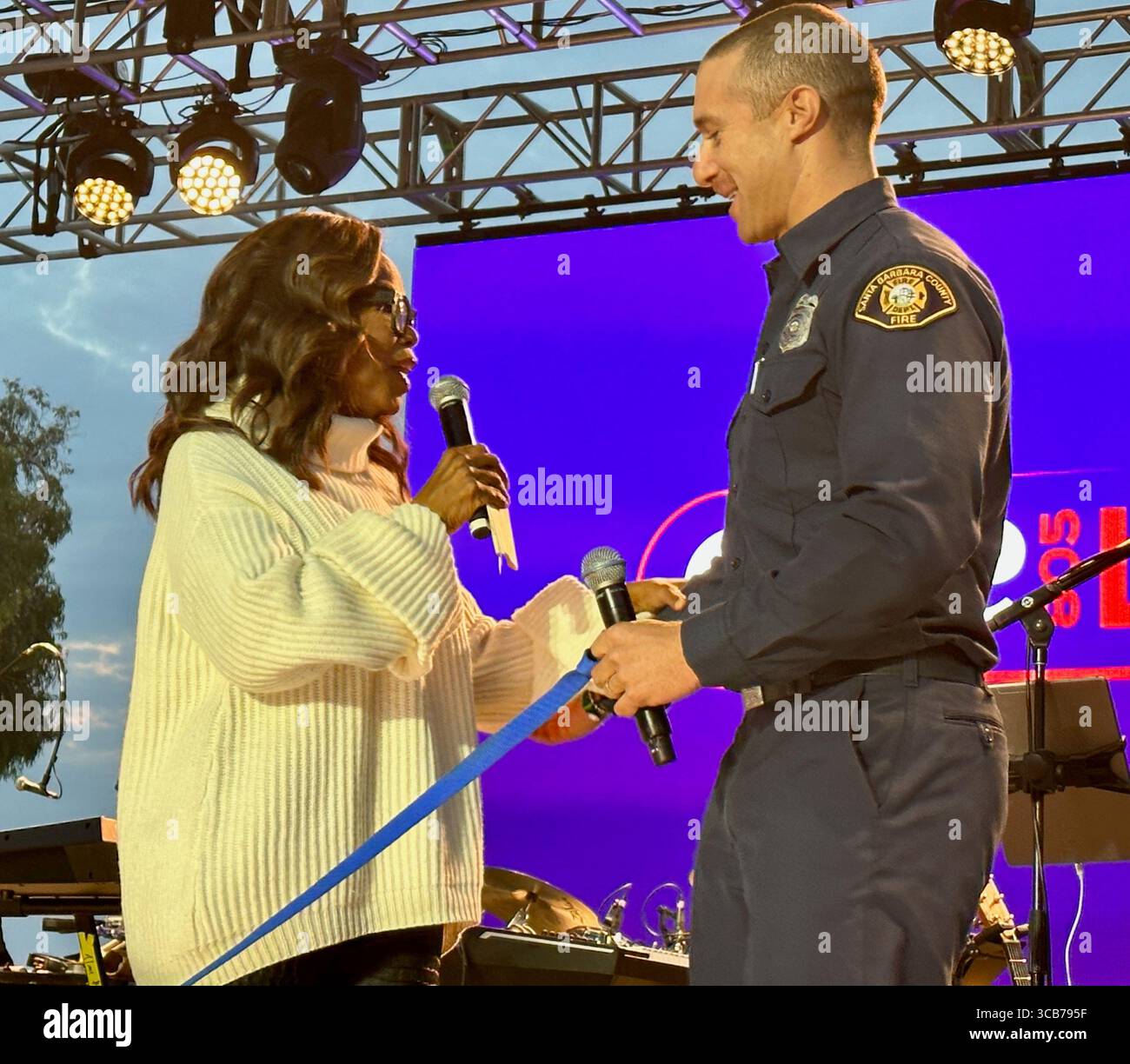 22. September 2023, Santa Barbara, Kalifornien, USA: Oprah Winfrey spricht offen und emotional mit dem Feuerwehrmann Sam Dudley von Santa Barbara, einem der ersten Helfer, der von den Millionen Dollar profitieren wird, die beim One805 Live-Konzert und VIP-Dinner im Kevin Costnerâ Anwesen am Meer gesammelt werden. Dies ist eine jährliche Spendenaktion im Wert von mehreren Millionen Dollar, die von One805.org durchgeführt wird, um Ersthelfer im Santa Barbara County zu unterstützen, darunter Polizei, Fire und Search and Rescue. Dieses Jahr gehen die meisten Mittel an First Responder psychische Gesundheit. (Bild: © Amy Katz/ZUMA Press Wire) Stockfoto