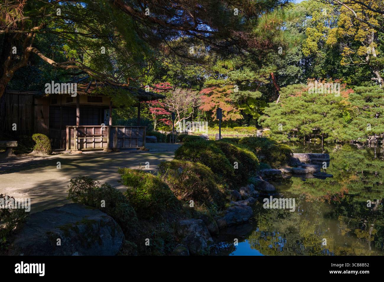 Heian-Schrein-Garten mit einem ruhigen Teich, üppigen Bäumen und einem einladenden kleinen Holzpavillon unter lebendigem Laub, der Ruhe und Harmonie ausstrahlt Stockfoto