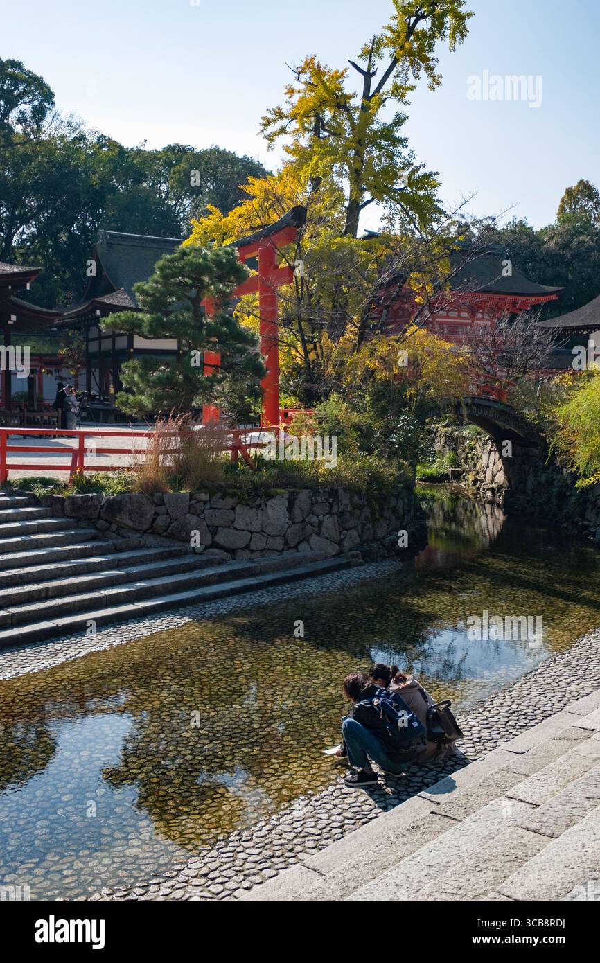 Shimogamo-Schrein mit lebendiger Architektur, reflektierendem Wasser und Menschen, die die friedliche Umgebung in der Natur genießen, Kyoto, Japan Stockfoto
