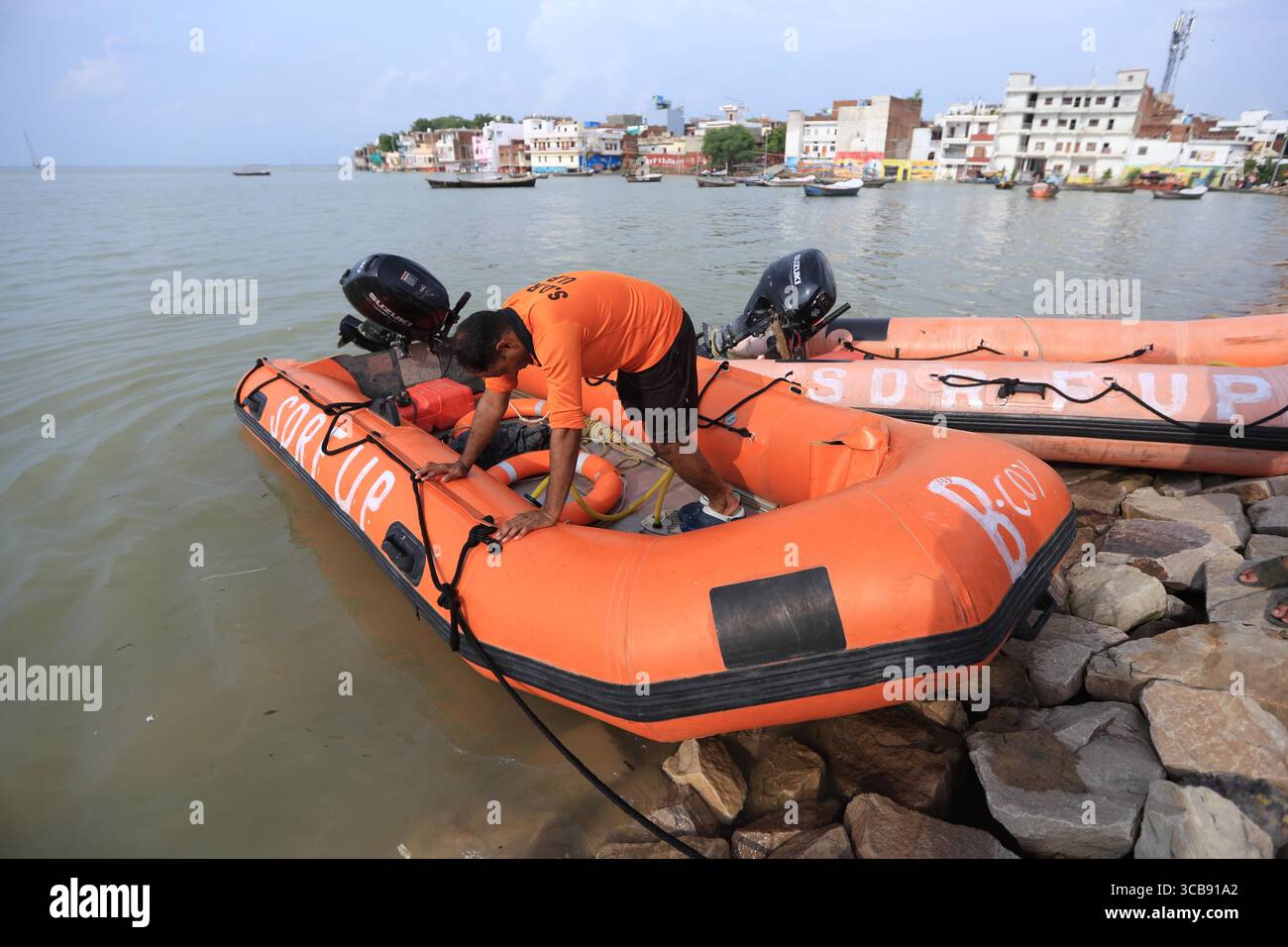 Mitglieder der State Disaster Response Force der SDRF retten gestrandete Bewohner in einem untergetauchten Gebiet des überfluteten Ganges in Prayagraj. Stockfoto