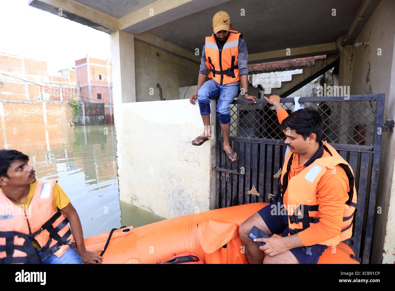 Mitglieder der State Disaster Response Force der SDRF retten gestrandete Bewohner in einem untergetauchten Gebiet des überfluteten Ganges in Prayagraj. Stockfoto