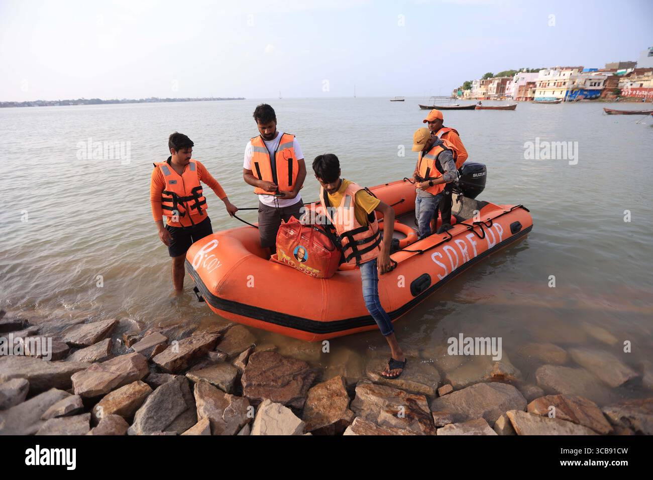 Mitglieder der State Disaster Response Force der SDRF retten gestrandete Bewohner in einem untergetauchten Gebiet des überfluteten Ganges in Prayagraj. Stockfoto