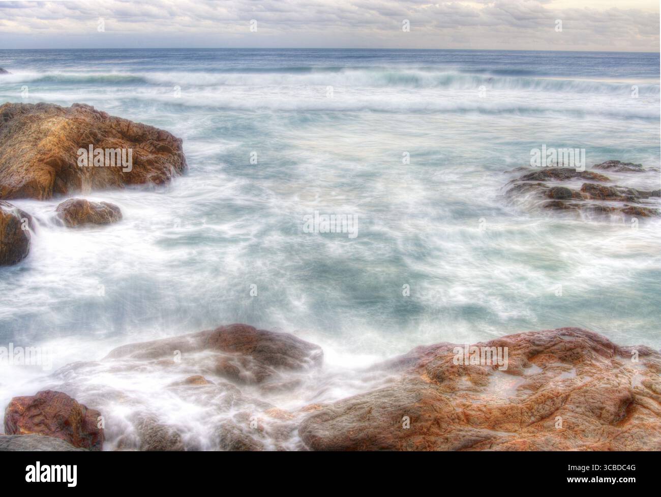 Weiches Wasser auf Felsen am Hafen von coffs Stockfoto