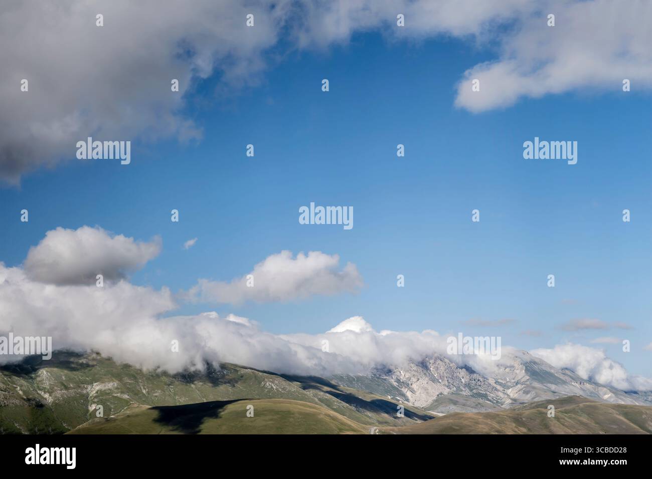 Luftlandschaft mit Meeresbrise, Wolken, die das Laga-Gebirge umhüllen, aufgenommen von einem Segelflugzeug im hellen Sommerlicht, L'Aquila, Abruzzen, Italien Stockfoto