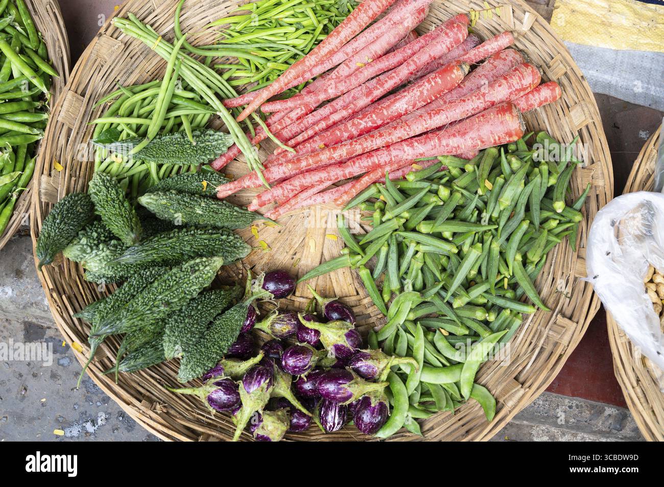 Korb mit frischem Gemüse, Markt in Indien, Verkaufsstand auf der Straße mit Karotten, Auberginen, Bohnen, Okra-Schoten und Gurken, indische Kultur Stockfoto