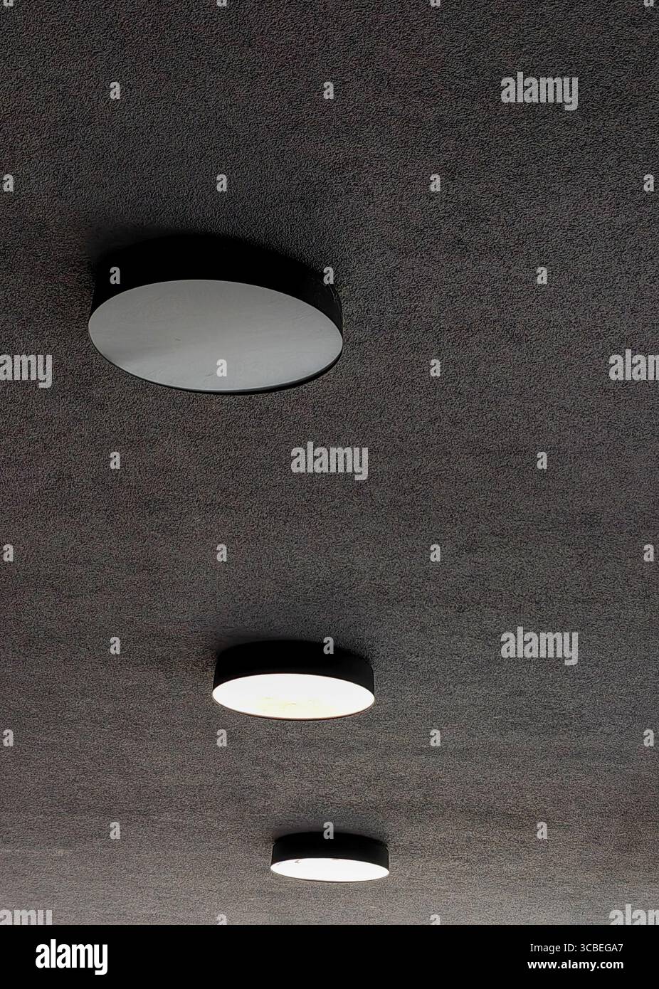 Drei runde Deckenleuchten in vertikaler Perspektive Stockfoto