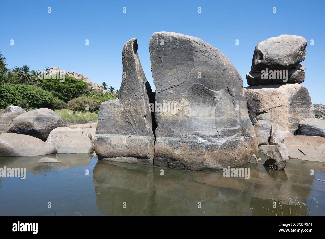 Zyklopenischer Granitfelsen im Fluss Tungabhadra, Wasserspiegelung, felsige Landschaft, Hampi, Südindien, Karnataka Stockfoto