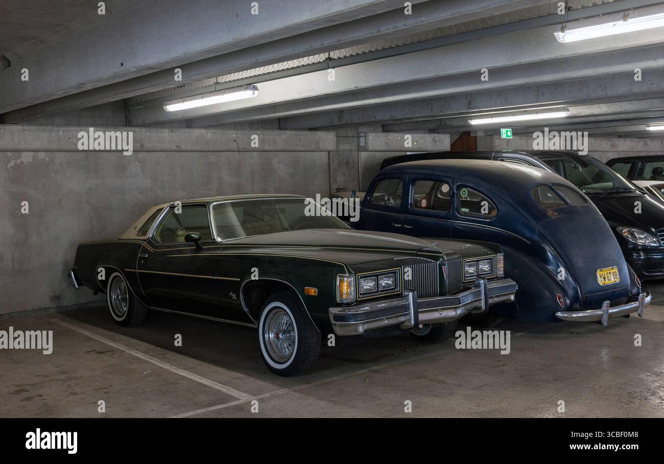 1976 Pontiac Grand Prix, ein klassischer amerikanischer Muscle Car, der in einer modernen Parkgarage parkt. Stockfoto