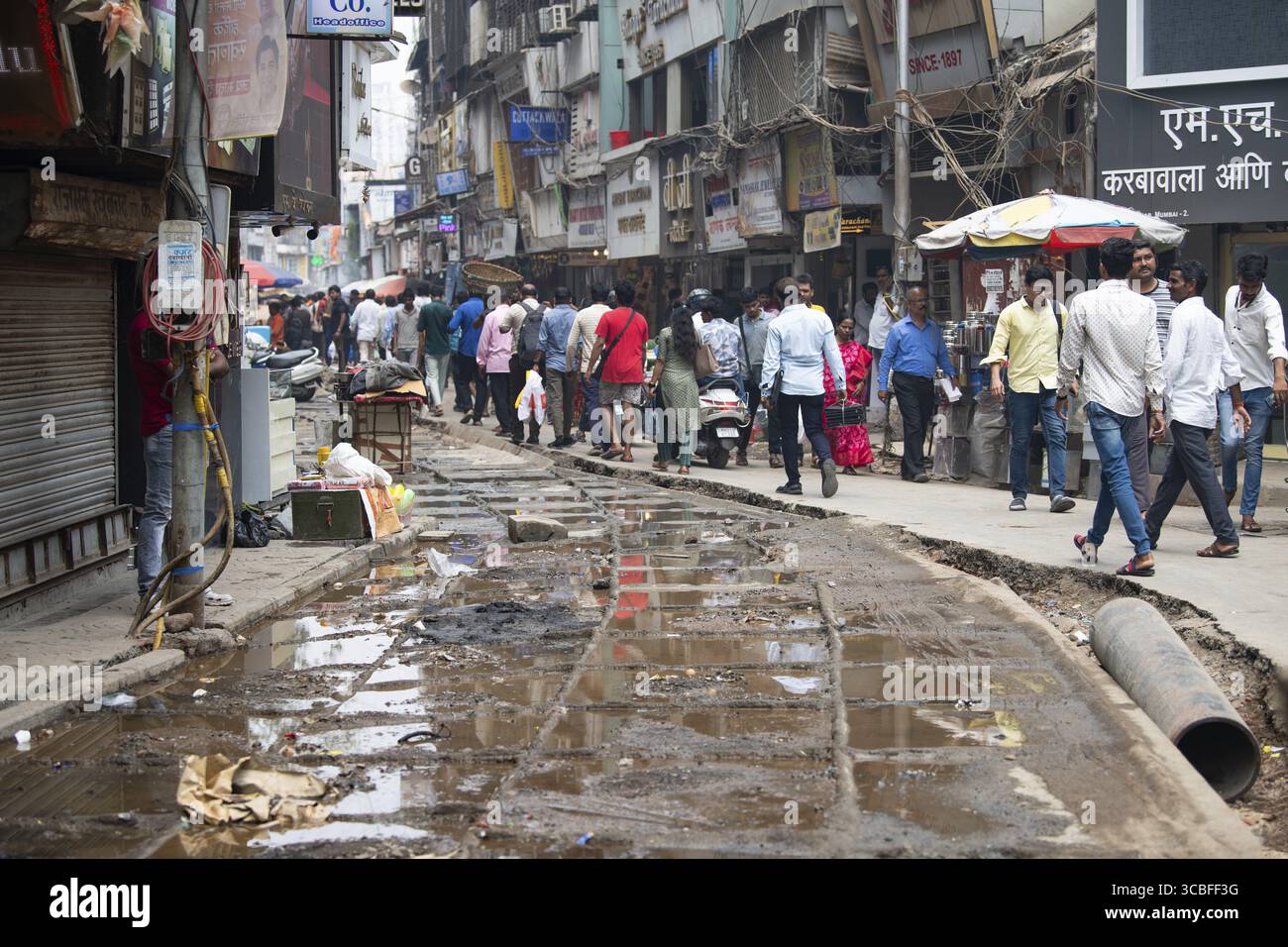 Straßen von Mumbai, Indien, Baustelle und Menschen, ausgehobene Straße gefüllt mit schmutzigem, stinkendem Wasser, ungesicherte beschädigte Straße, 02.04.2025 Stockfoto