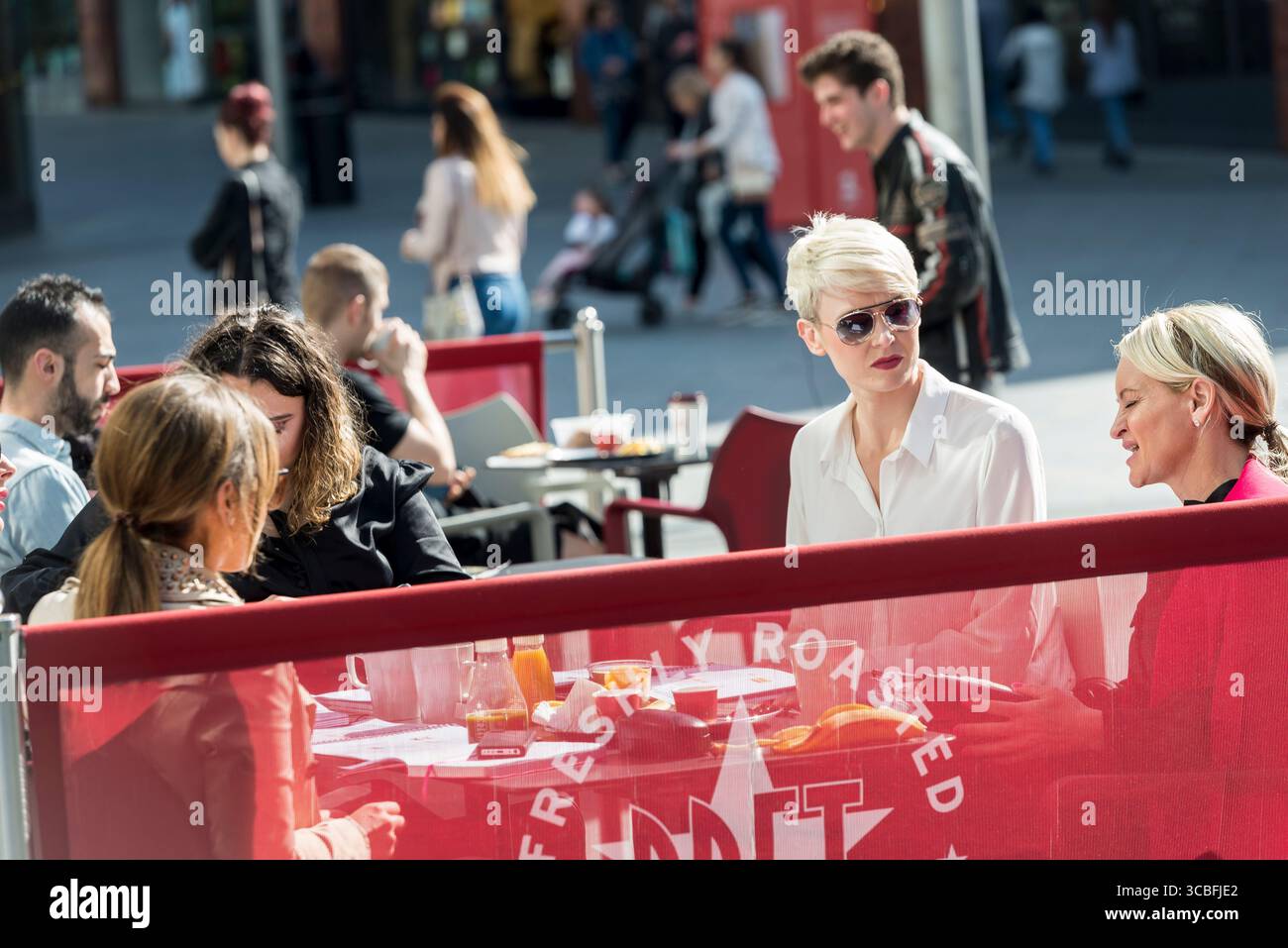 Hektische Mittagsmenschen genießen an einem sonnigen Tag ein Abendessen im Freien in einem Café im Stadtzentrum von Liverpool. Stockfoto