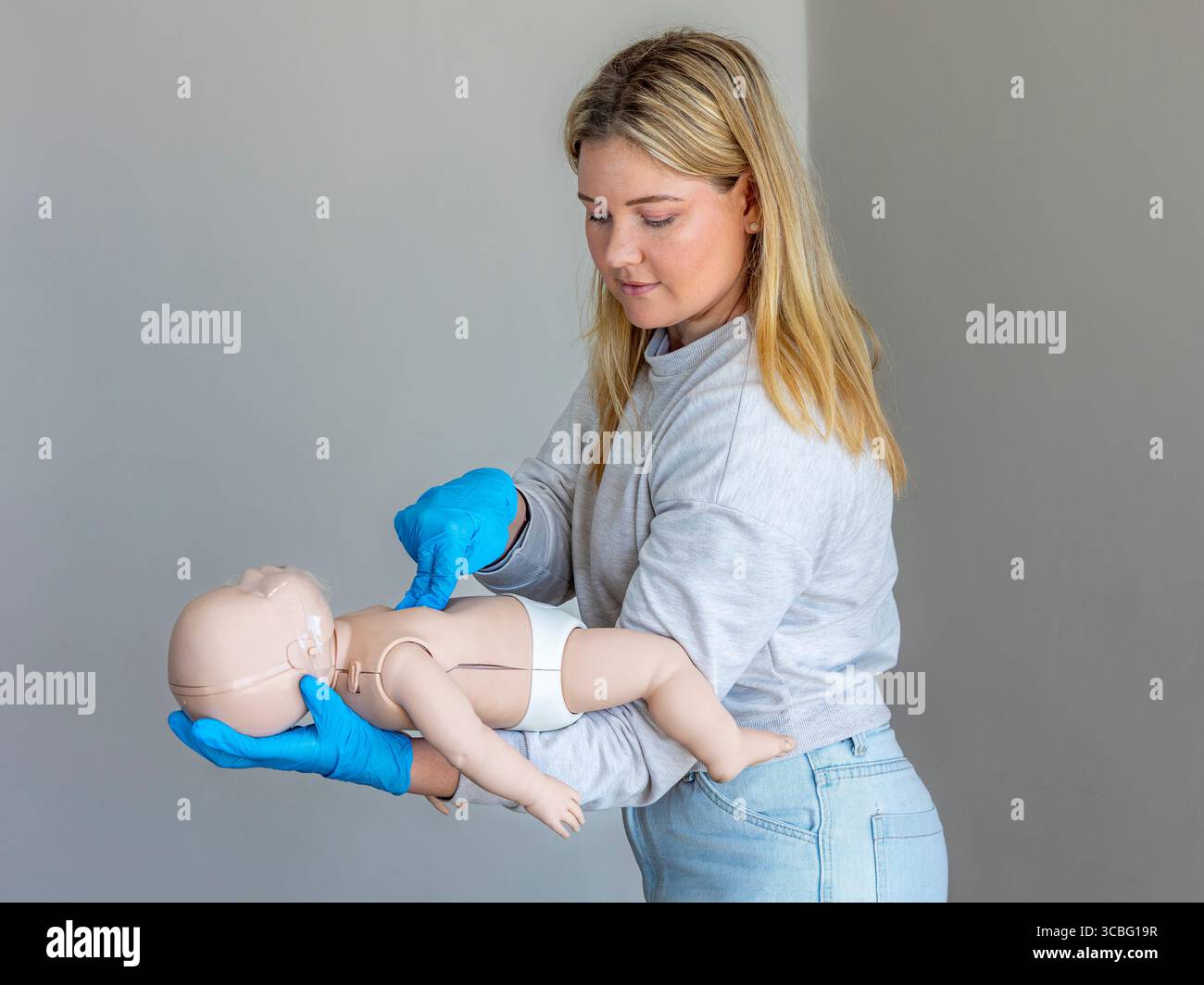 Nahaufnahme einer erste-Hilfe-Ausbilderin, die die richtige Technik für die Durchführung von Thoraxkompressionen an einer Basic Life Support für Kleinkinder demonstriert ( Stockfoto