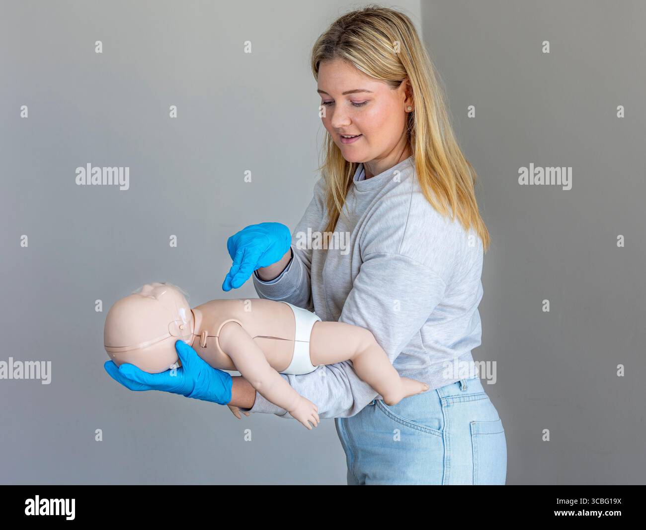 Nahaufnahme einer erste-Hilfe-Ausbilderin, die die richtige Technik für die Durchführung von Thoraxkompressionen an einer Basic Life Support für Kleinkinder demonstriert ( Stockfoto