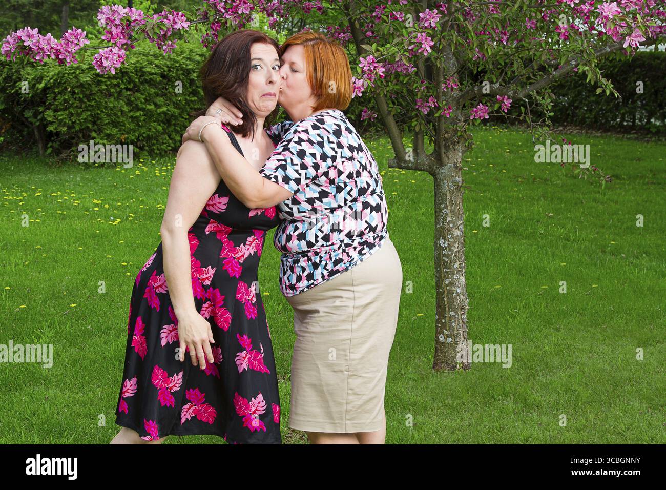 Frau überrascht einen Kuss auf die Wange eines Freundes Stockfoto