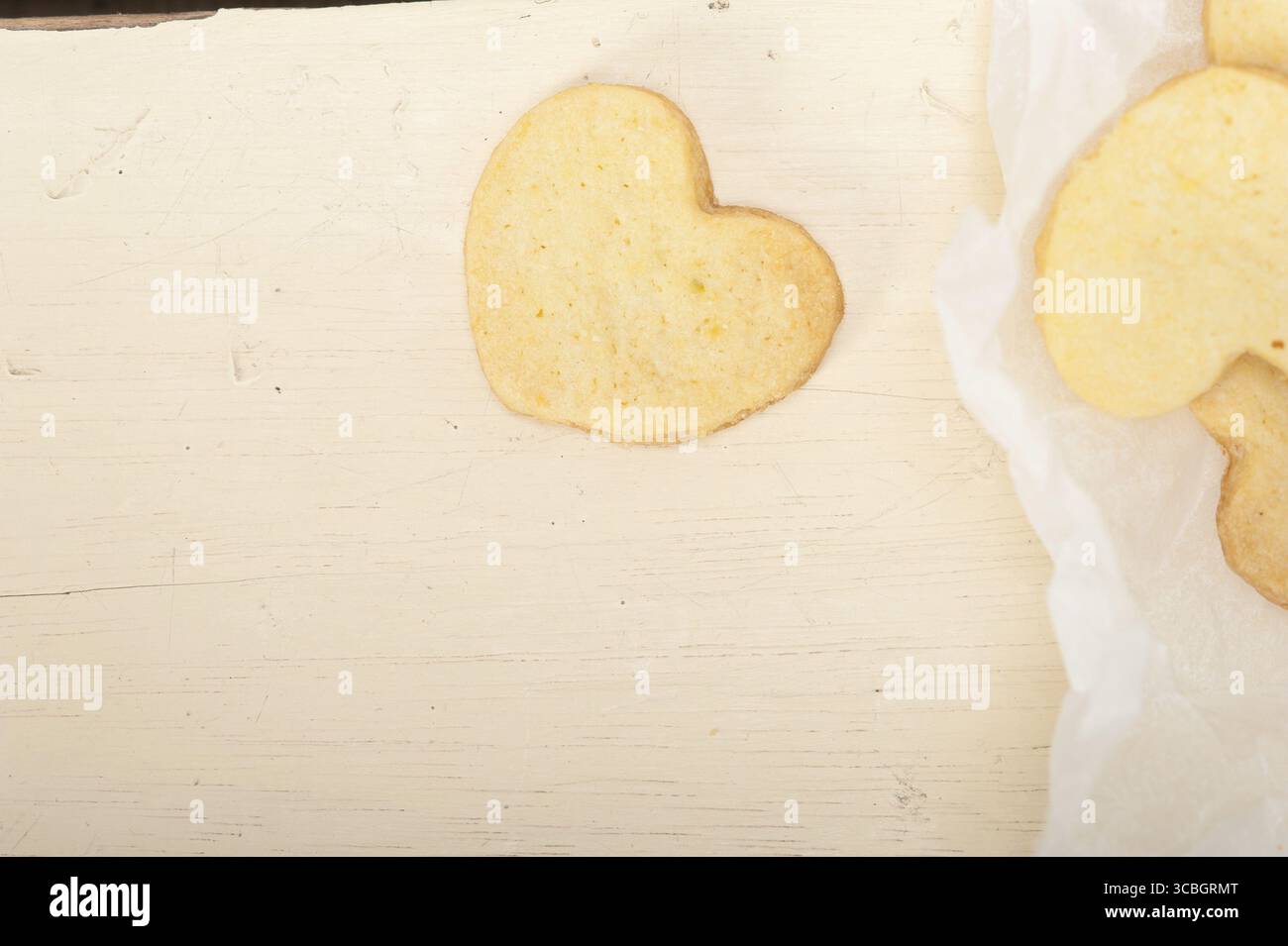 Frisch gebackenes, herzförmiges Shortbread zum valentinstag Kekse auf einer Papierfolie Stockfoto