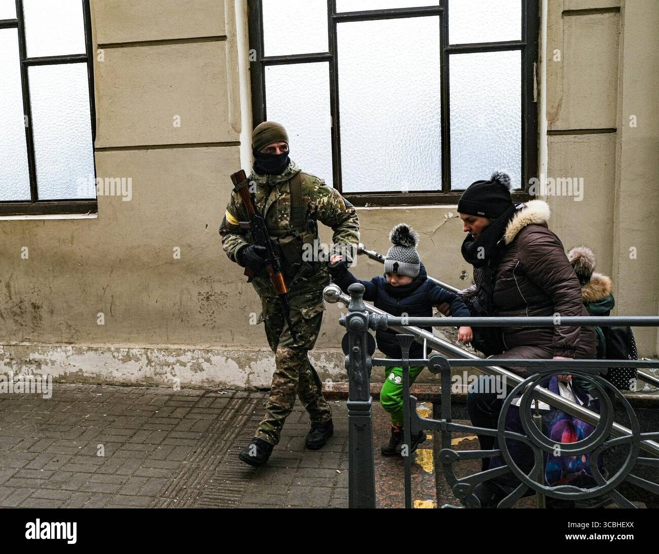 3. März 2022, Ukraine: Ein ukrainischer Soldat hilft, eine fliehende Familie zu einem Zug zu führen, der am 3. März 2022 am Lviv-Hauptbahnhof in Lemberg, Ukraine, nach Polen fuhr. (Bild: © Byron Smith/ZUMA Press Wire) Stockfoto