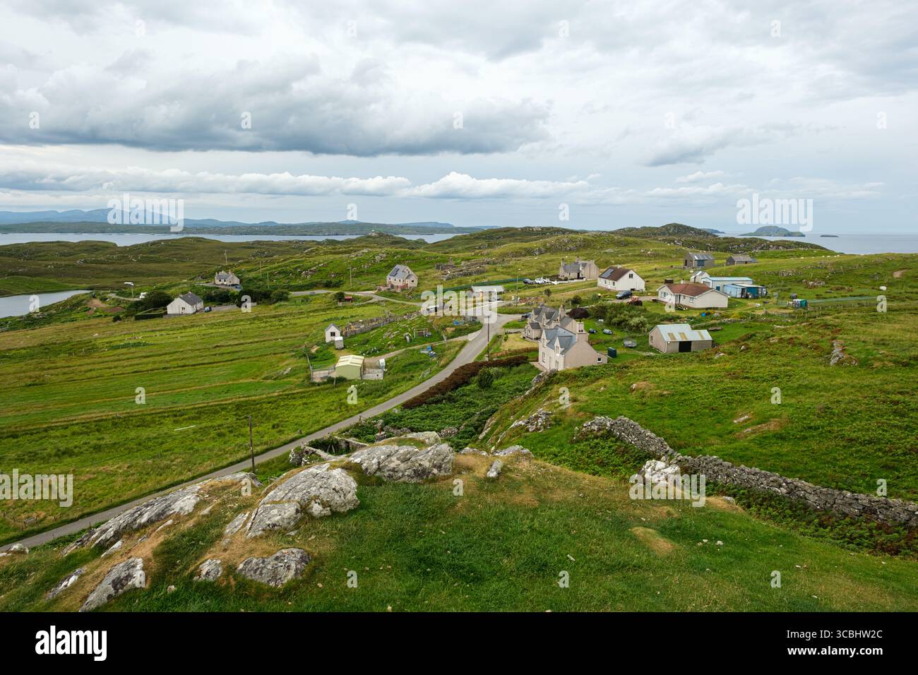 Häuser in Carloway (Chàrlabhaigh) Dorf mit Dun Carloway Broch in der Nähe auf der Isle of Lewis, Äußere Hebriden, Schottland, mit Blick auf die Küstenlandschaft. Stockfoto