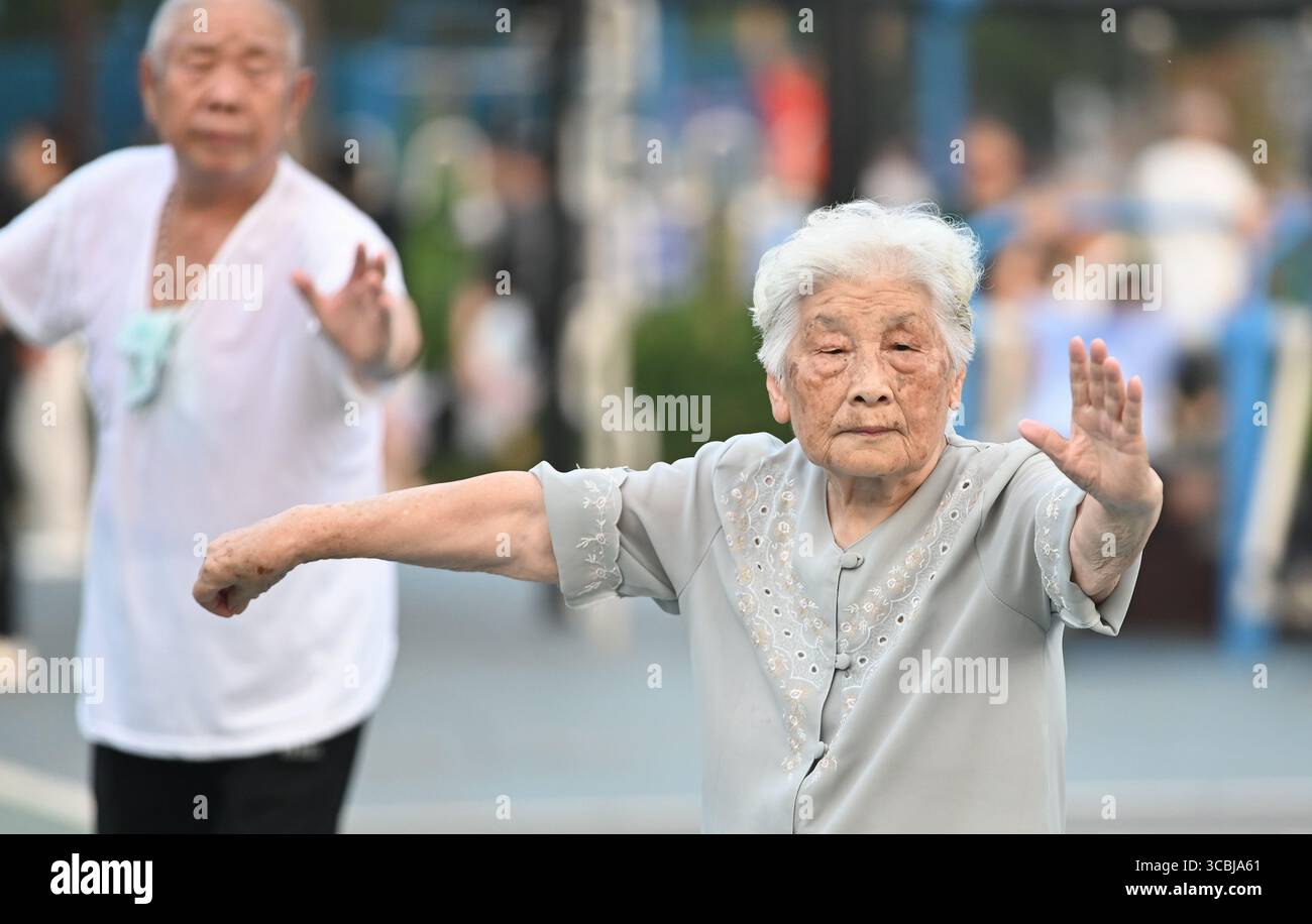 Peking, Chinas Provinz Shandong. August 2025. Senioren üben Tai Chi in einem Park in der Stadt Tengzhou, ostchinesische Provinz Shandong, 8. August 2025. Da das Land diesen Freitag den nationalen Fitness-Tag begeht, ein Erbe der Olympischen Spiele 2008 in Peking, nehmen immer mehr Menschen einen aktiven Lebensstil auf. Quelle: Li Zhijun/Xinhua/Alamy Live News Stockfoto