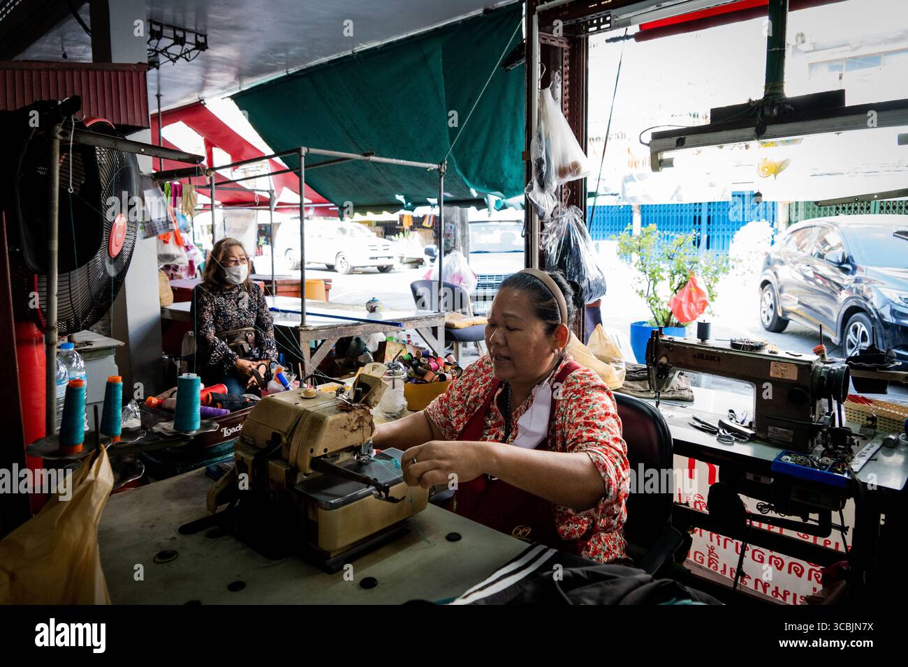 10. Februar 2023 in Bangkok, Bangkok, Thailand: Eine Schneiderin arbeitet an ihrer Nähmaschinenstation in einem Außenmarkt in Bangkok. (Kreditbild: © Matt Hunt/ZUMA Press Wire) Stockfoto