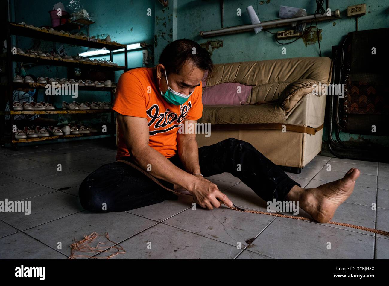 10. Februar 2023, Bangkok, Thailand: Ein Arbeiter trimmt Leder, während er Schuhe in einem Sweatshop in Ost-Bangkok herstellt. (Kreditbild: © Matt Hunt/ZUMA Press Wire) Stockfoto