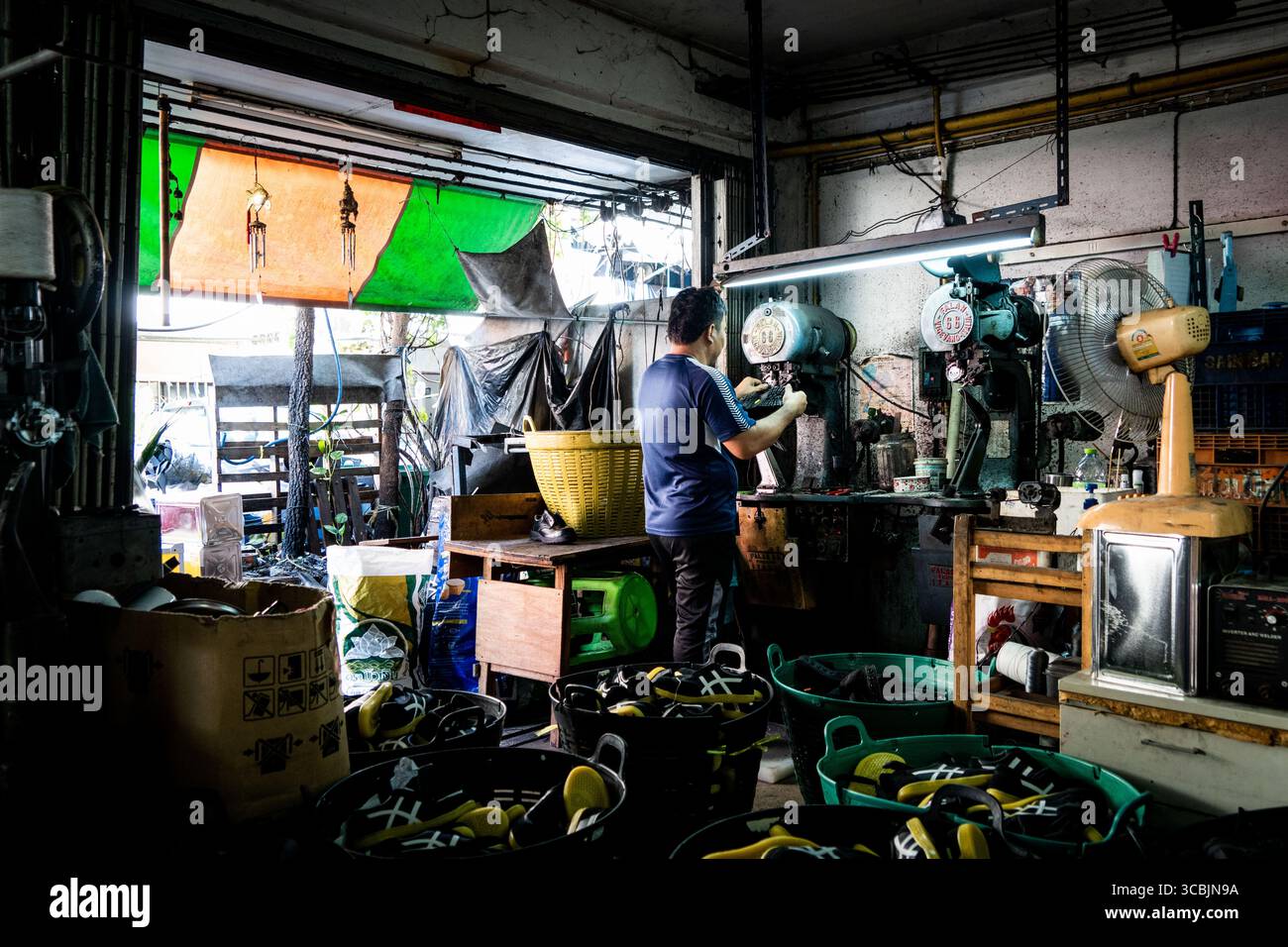 10. Februar 2023 in Bangkok, Bangkok, Thailand: Ein Arbeiter, der zwischen Schuhen steht, wird in einem Sweatshop in Ost-Bangkok beim Nähen gesehen. (Kreditbild: © Matt Hunt/ZUMA Press Wire) Stockfoto