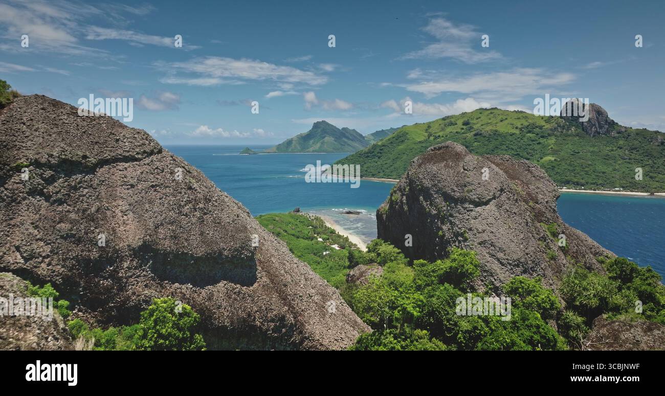 Atemberaubende Aussicht auf tropische Inseln aus dem türkisfarbenen Ozean, eingerahmt von majestätischen Felsen, die eine atemberaubende Landschaft auf Fidschi schaffen. Fantastischer Naturreisehintergrund. Drohnenflug Stockfoto
