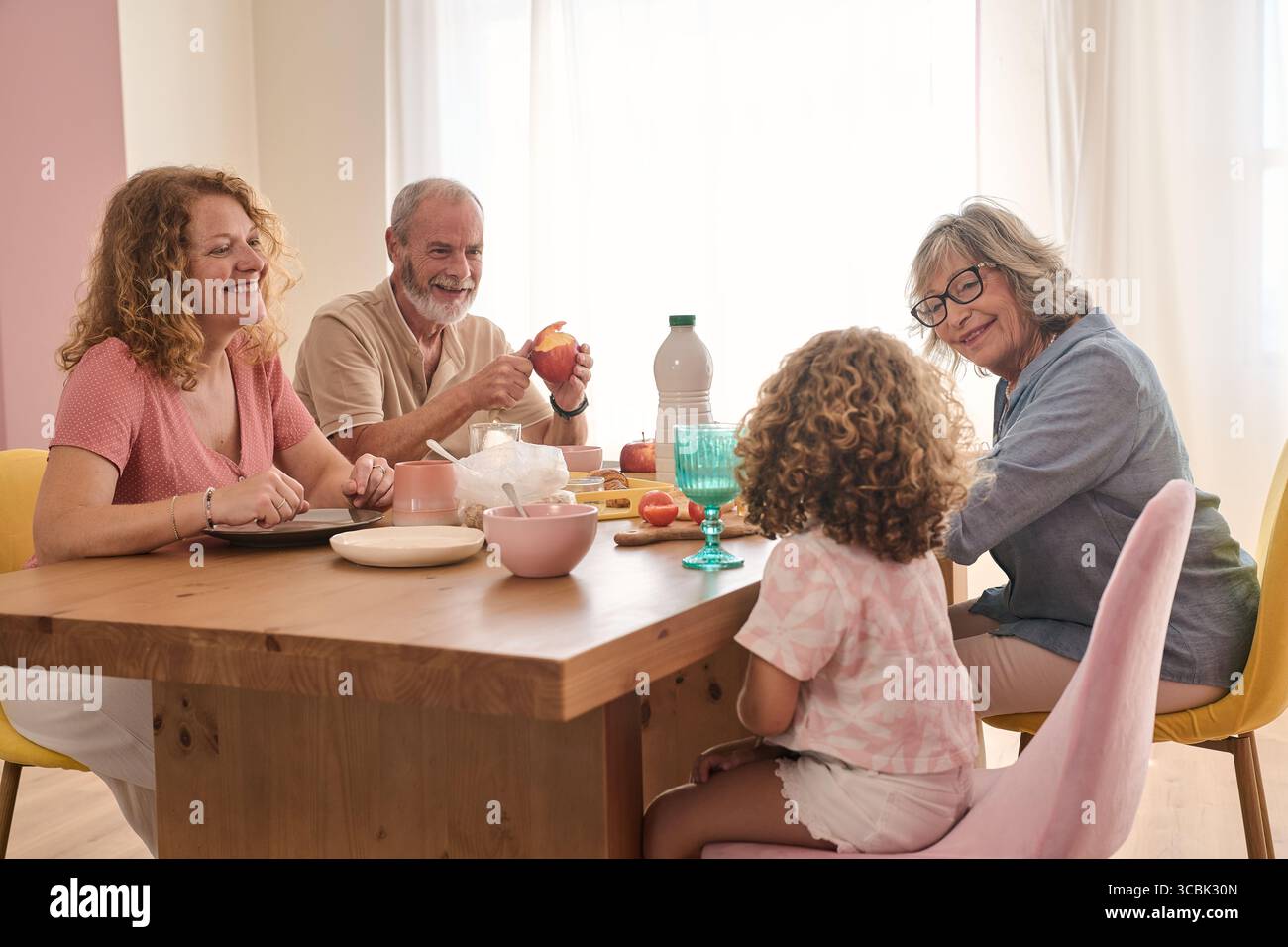 Glückliche Familie, die zu Hause das gemeinsame Frühstück genießt Stockfoto